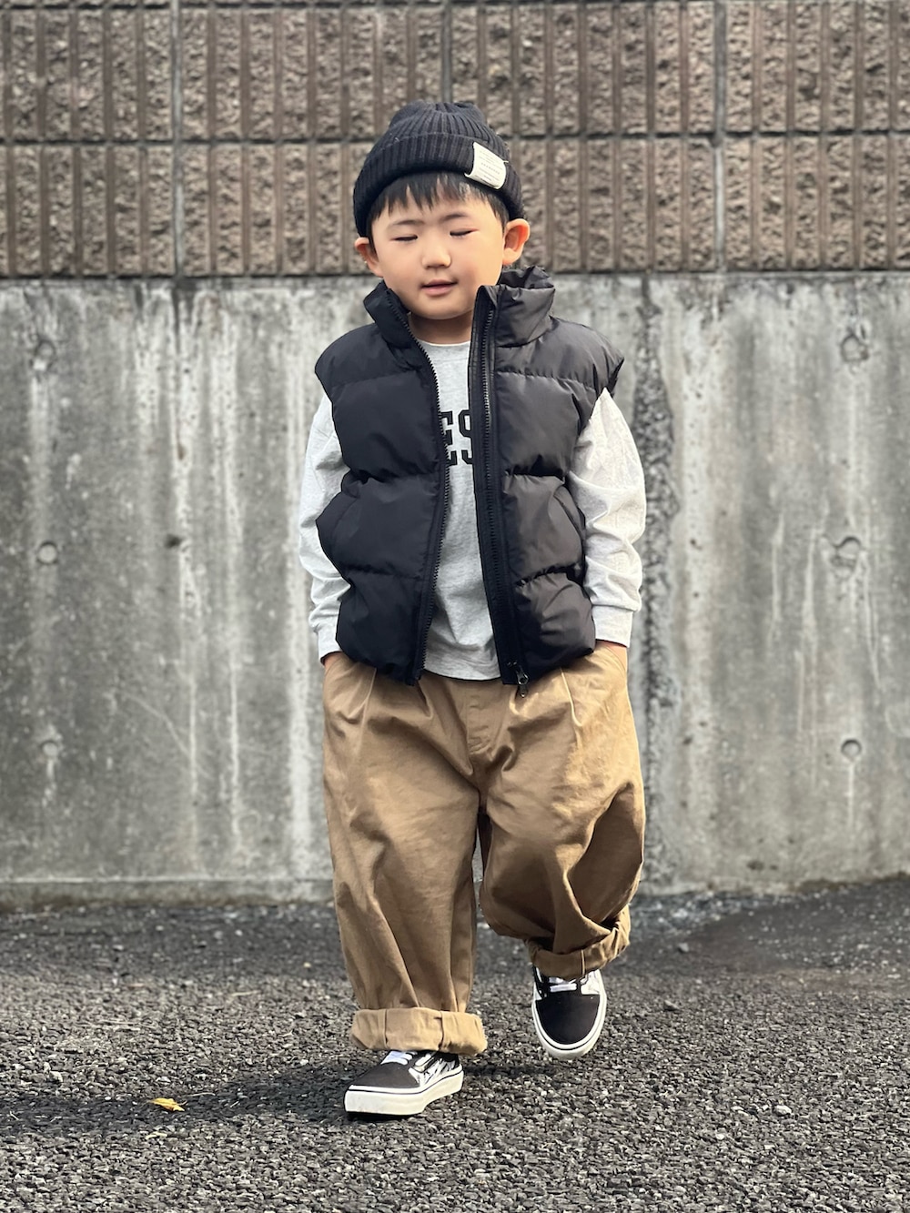ブラック系のベスト、ベージュ系のその他パンツを着用したキッズの秋コーディネートの2枚目の写真