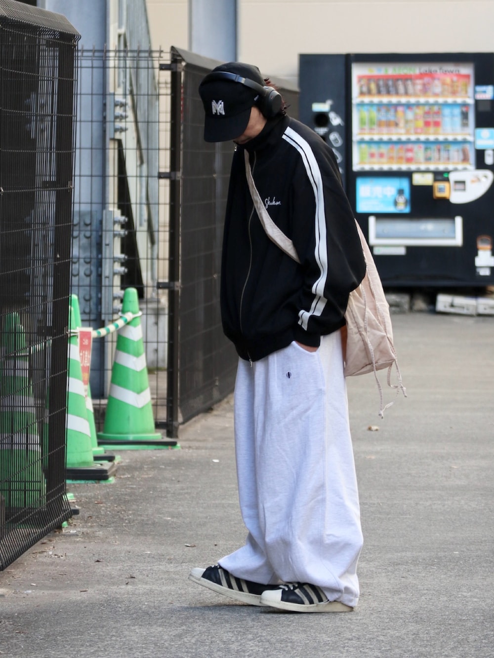 ブラック系のその他アウター、ホワイト系のスウェットパンツを着用したメンズの冬コーディネートの3枚目の写真