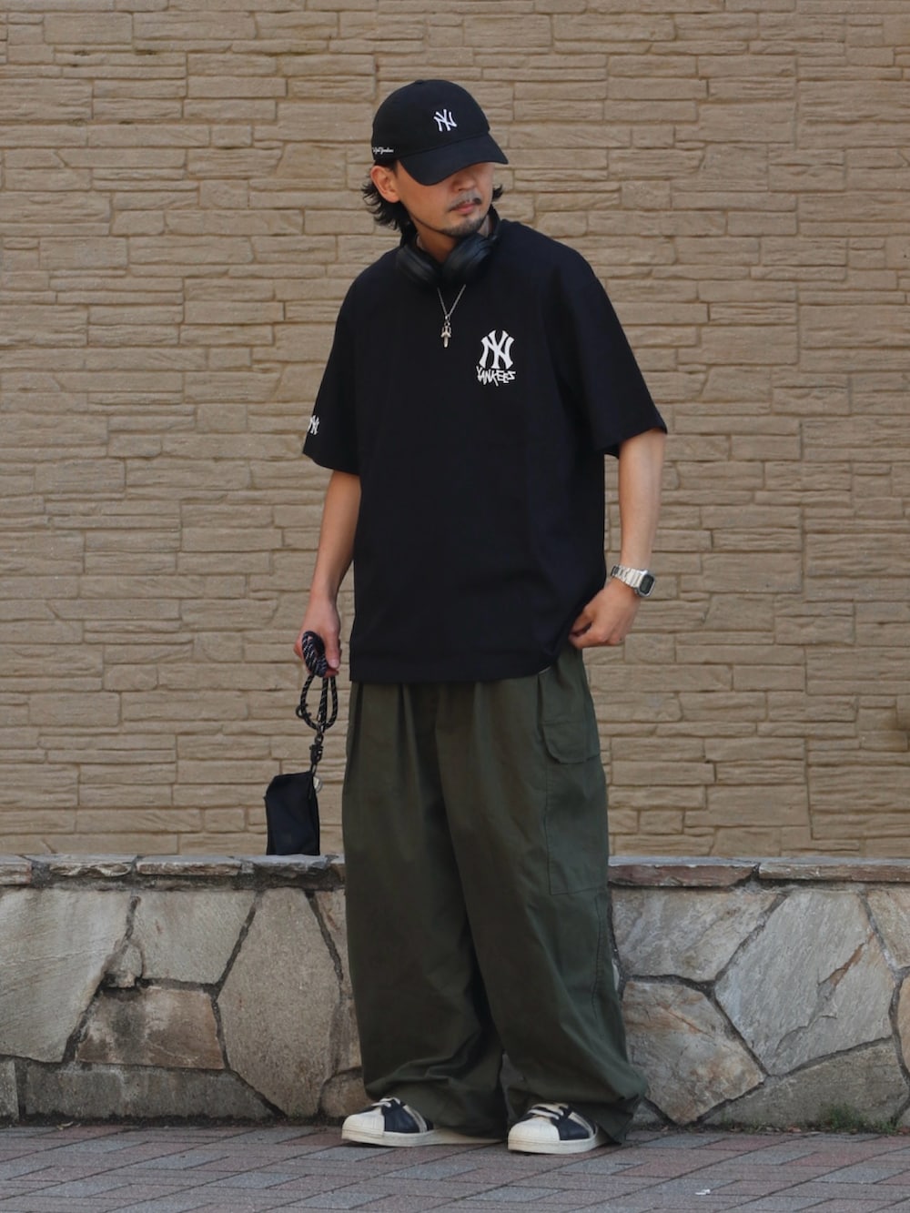 ブラック系のTシャツ/カットソー、グリーン系のその他パンツ、ブラック系のスマホケース/カバーを着用したメンズの夏コーディネートの2枚目の写真