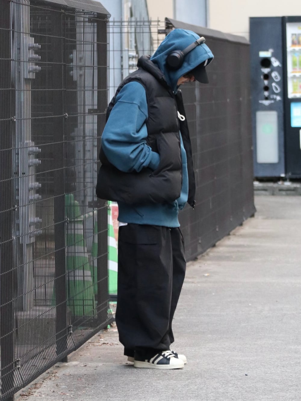 ブルー系のパーカー、ブラック系のダウンベスト、ブラック系のその他パンツを着用したメンズの冬コーディネートの2枚目の写真