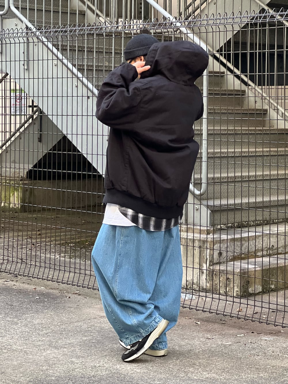 ブラック系のブルゾン、ブルー系のデニムパンツ、ブラック系のスニーカーを着用したメンズの冬コーディネートの2枚目の写真