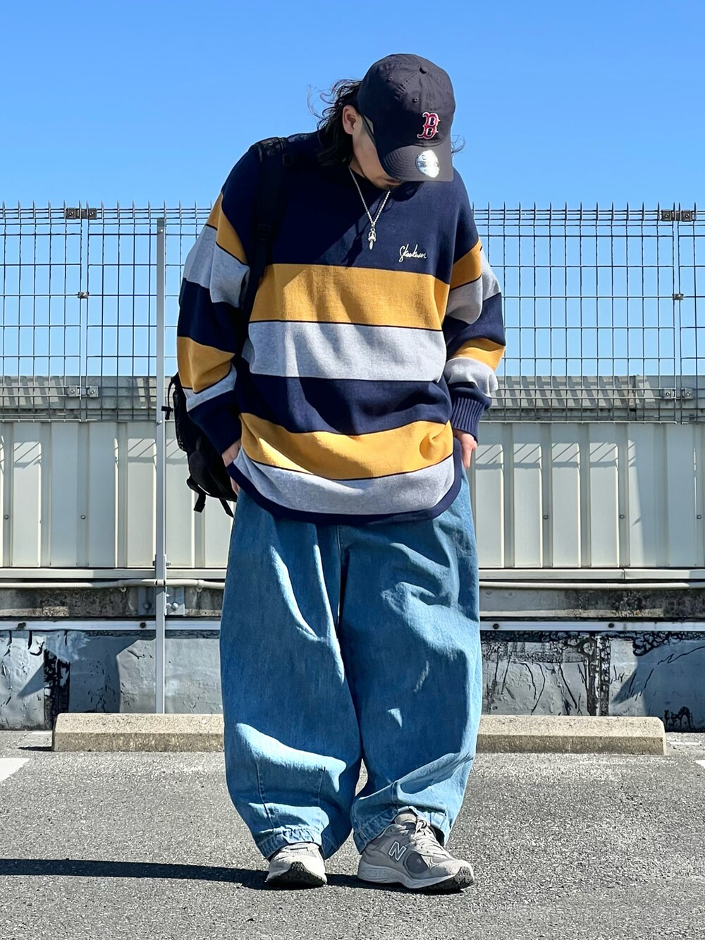 ブルー系のニット/セーター、ブルー系のデニムパンツ、グレー系のスニーカーを着用したメンズの冬コーディネートの2枚目の写真