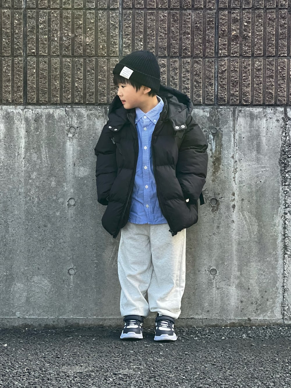 ブラック系のブルゾン、グレー系のスウェットパンツ、ホワイト系のスニーカーを着用したキッズの冬コーディネートの2枚目の写真