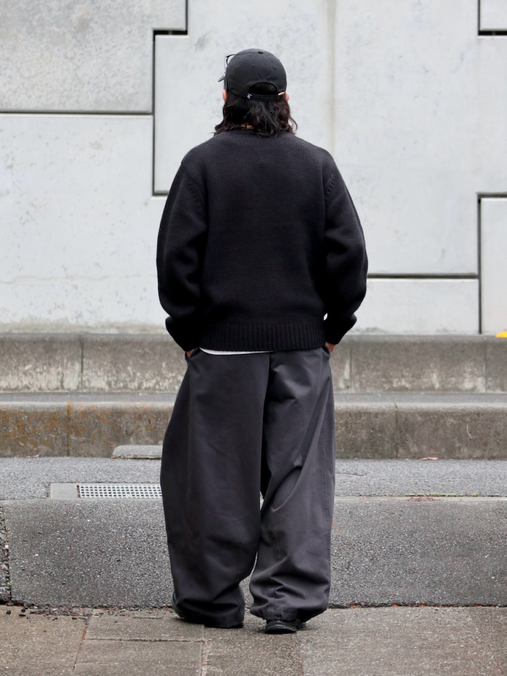 ブラック系のニット/セーター、ブラック系のスニーカー、グレー系のその他パンツを着用したメンズの秋コーディネートの4枚目の写真