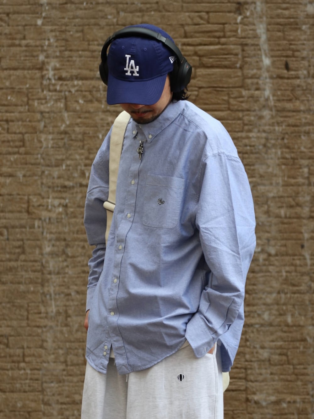 ブルー系のシャツ/ブラウス、ホワイト系のショルダーバッグを着用したメンズの春コーディネートの2枚目の写真