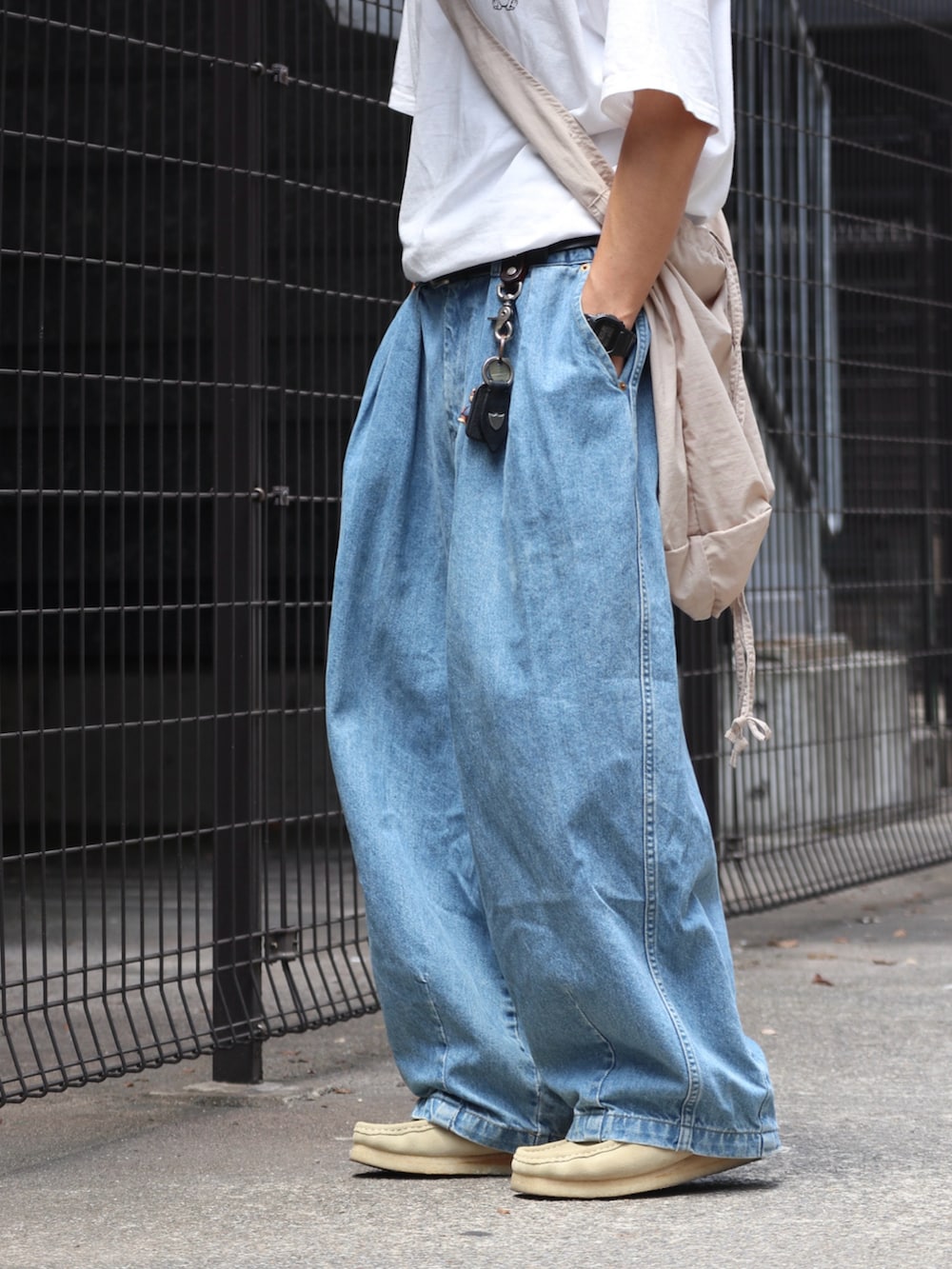 ホワイト系のTシャツ/カットソー、ブルー系のデニムパンツ、ベージュ系のモカシン/デッキシューズを着用したメンズの夏コーディネートの3枚目の写真