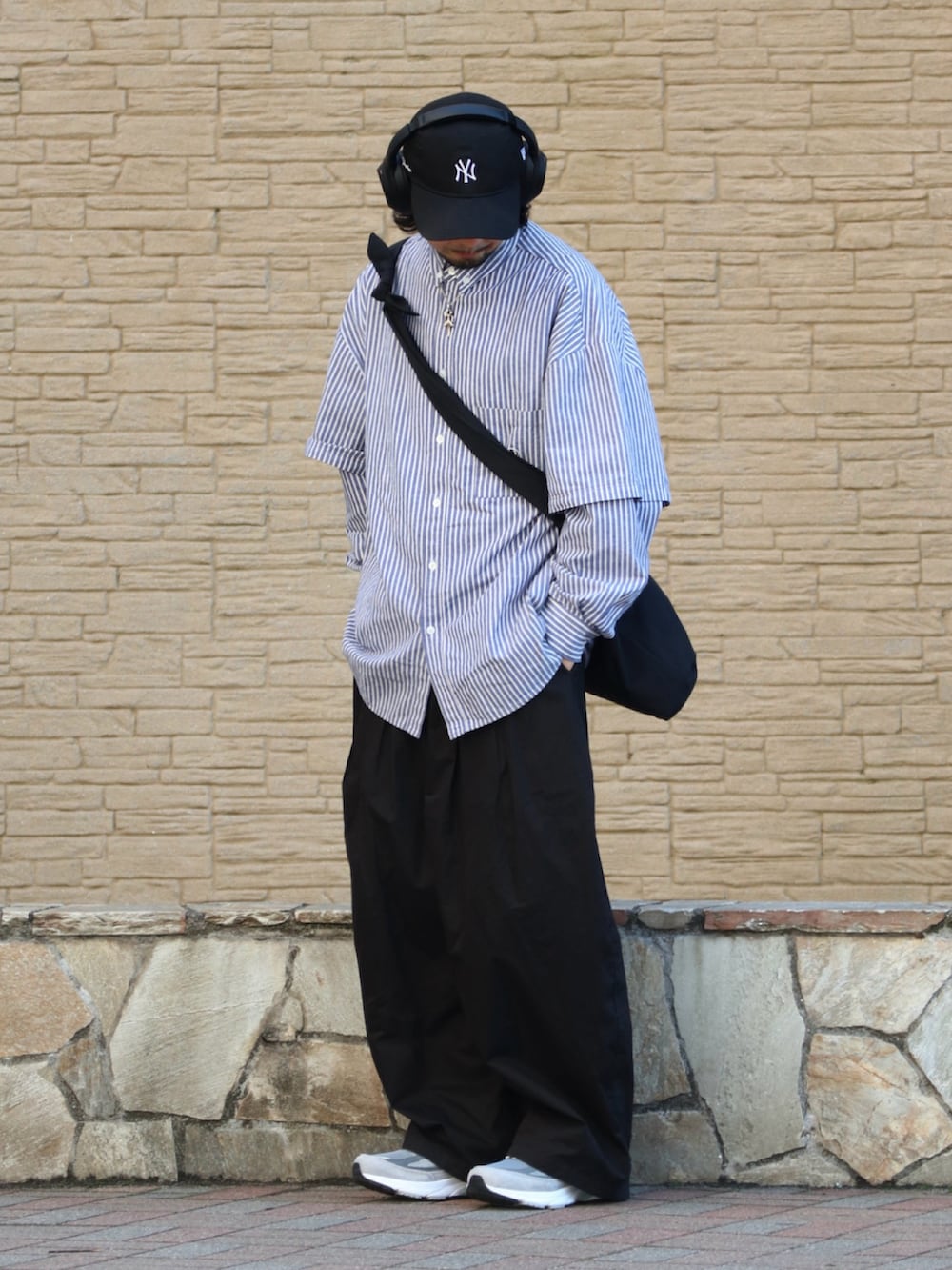 グレー系のスニーカー、ブラック系のチノパンツを着用したメンズの春コーディネートの2枚目の写真