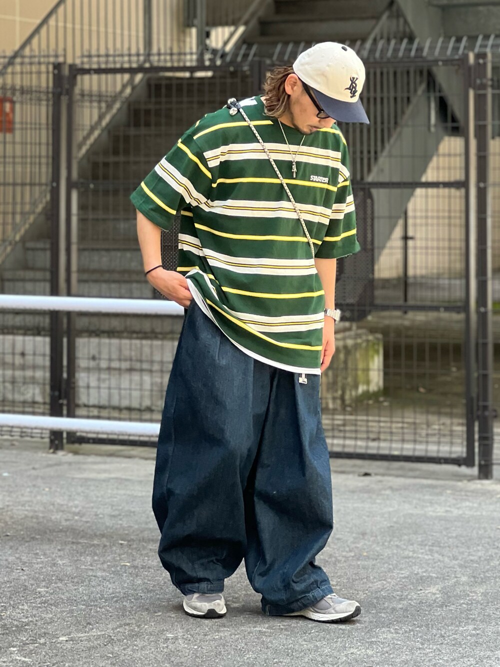 グリーン系のTシャツ/カットソー、ブルー系のデニムパンツ、グレー系のスニーカーを着用したメンズの夏コーディネートの2枚目の写真