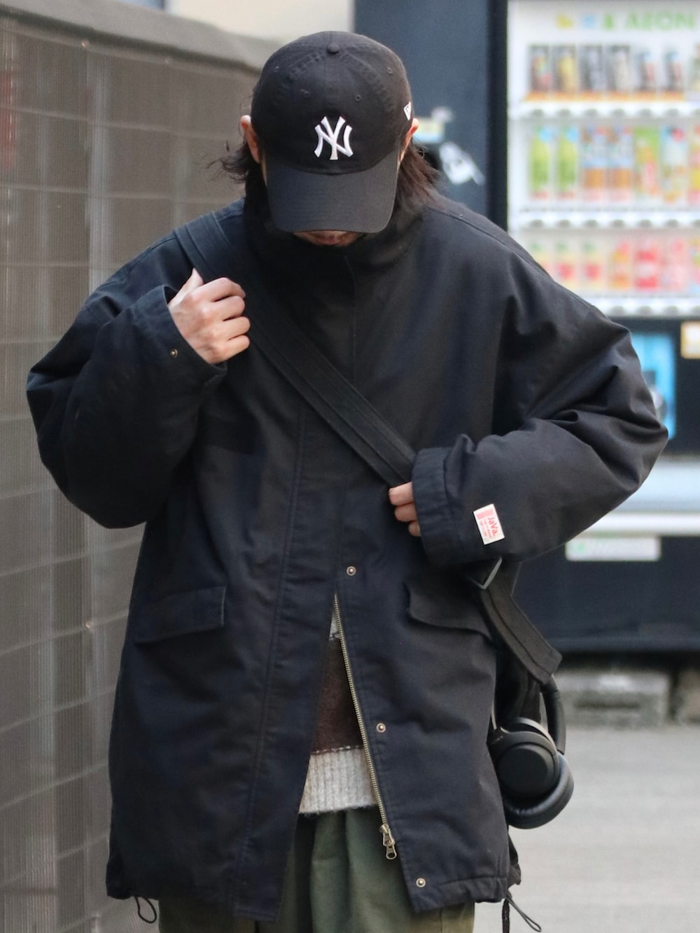 ブラック系のミリタリージャケットを着用したメンズの秋コーディネートの2枚目の写真