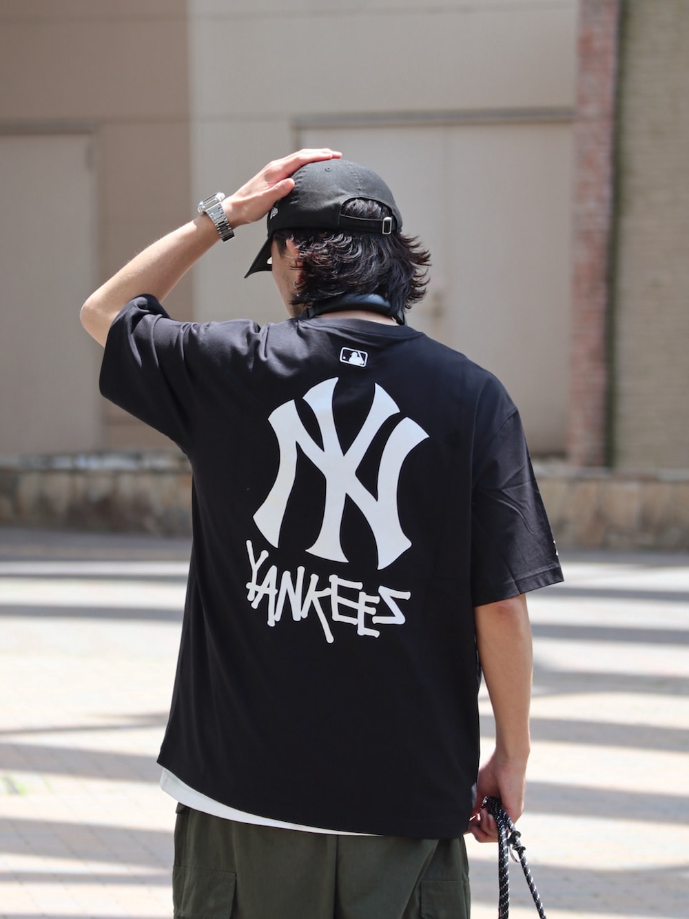 ブラック系のTシャツ/カットソー、グリーン系のその他パンツ、ブラック系のスマホケース/カバーを着用したメンズの夏コーディネートの3枚目の写真