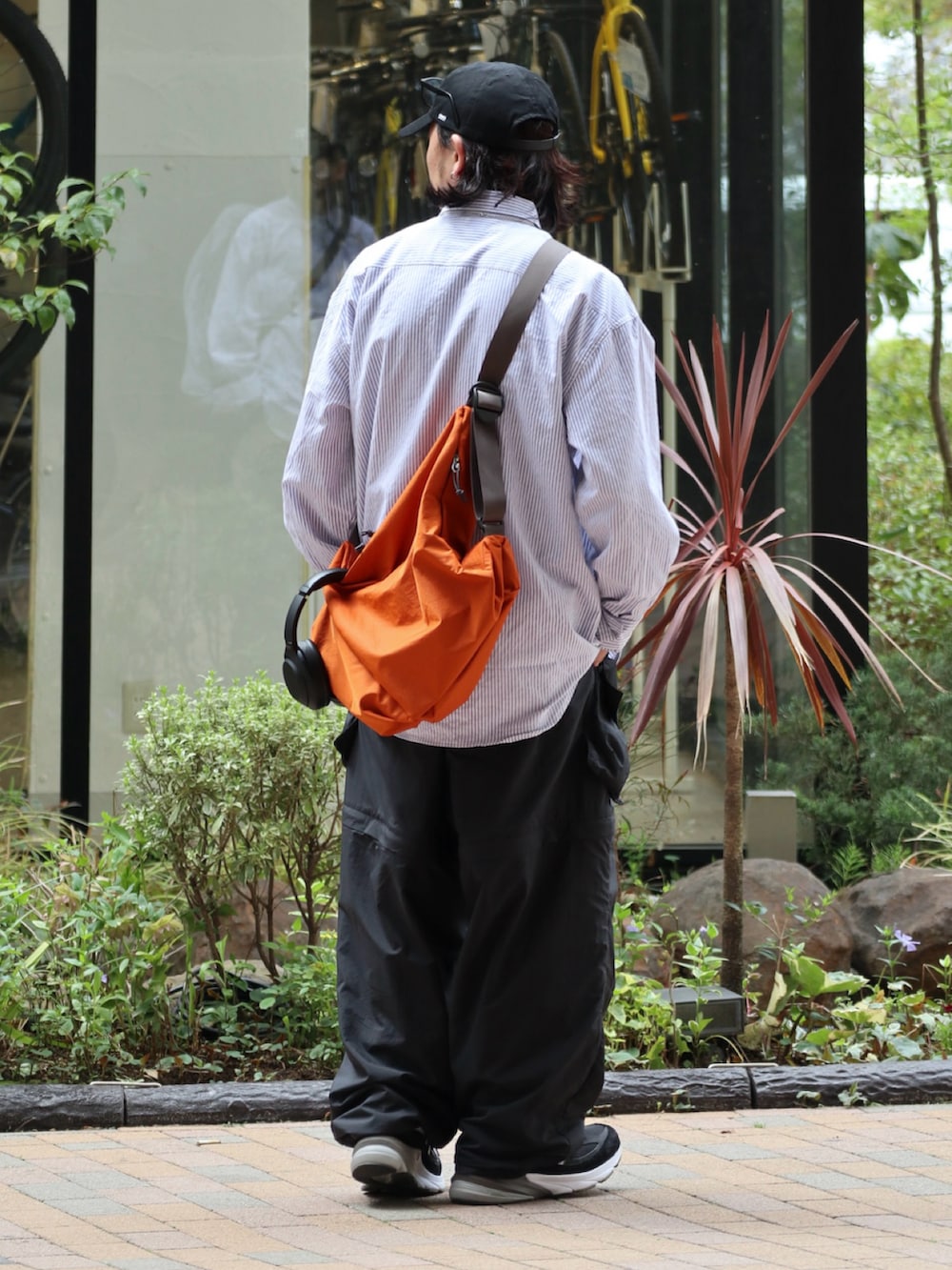オレンジ系のショルダーバッグ、その他のシャツ/ブラウス、ブラック系のその他パンツを着用したメンズの春コーディネートの2枚目の写真