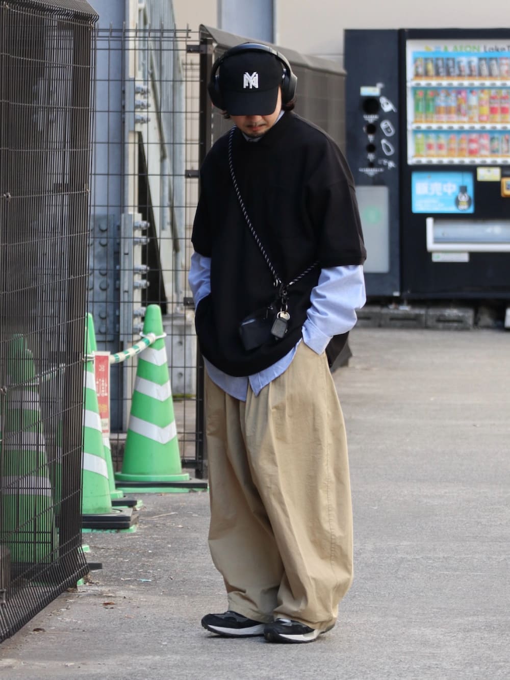 ブラック系のポロシャツ、ブラック系のスマホケース/カバーを着用したメンズの春コーディネートの2枚目の写真