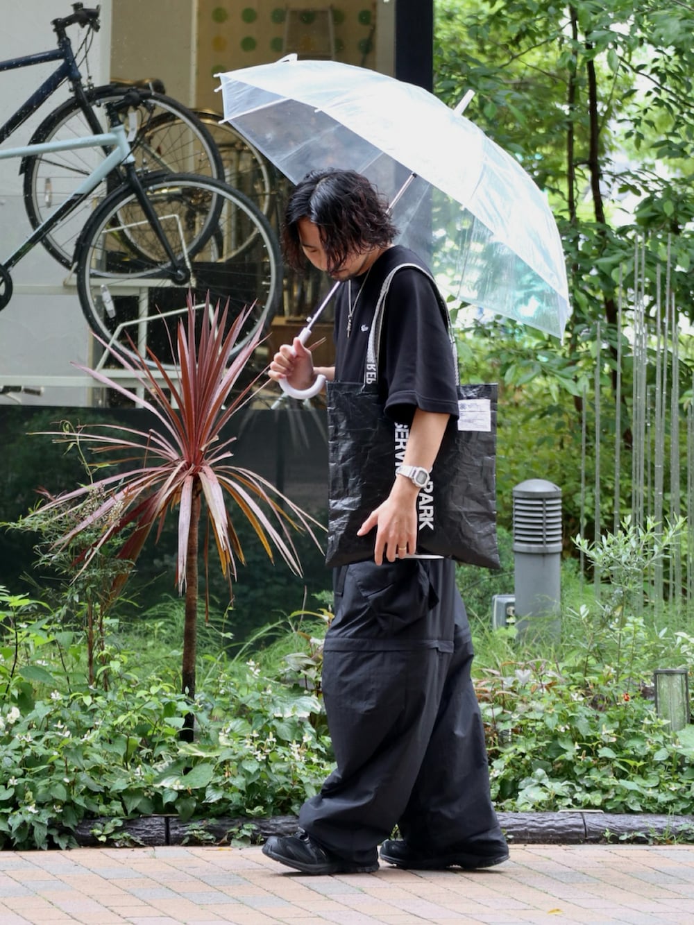 ブラック系のトートバッグ、ブラック系のTシャツ/カットソー、ブラック系のその他パンツを着用したメンズの夏コーディネートの2枚目の写真