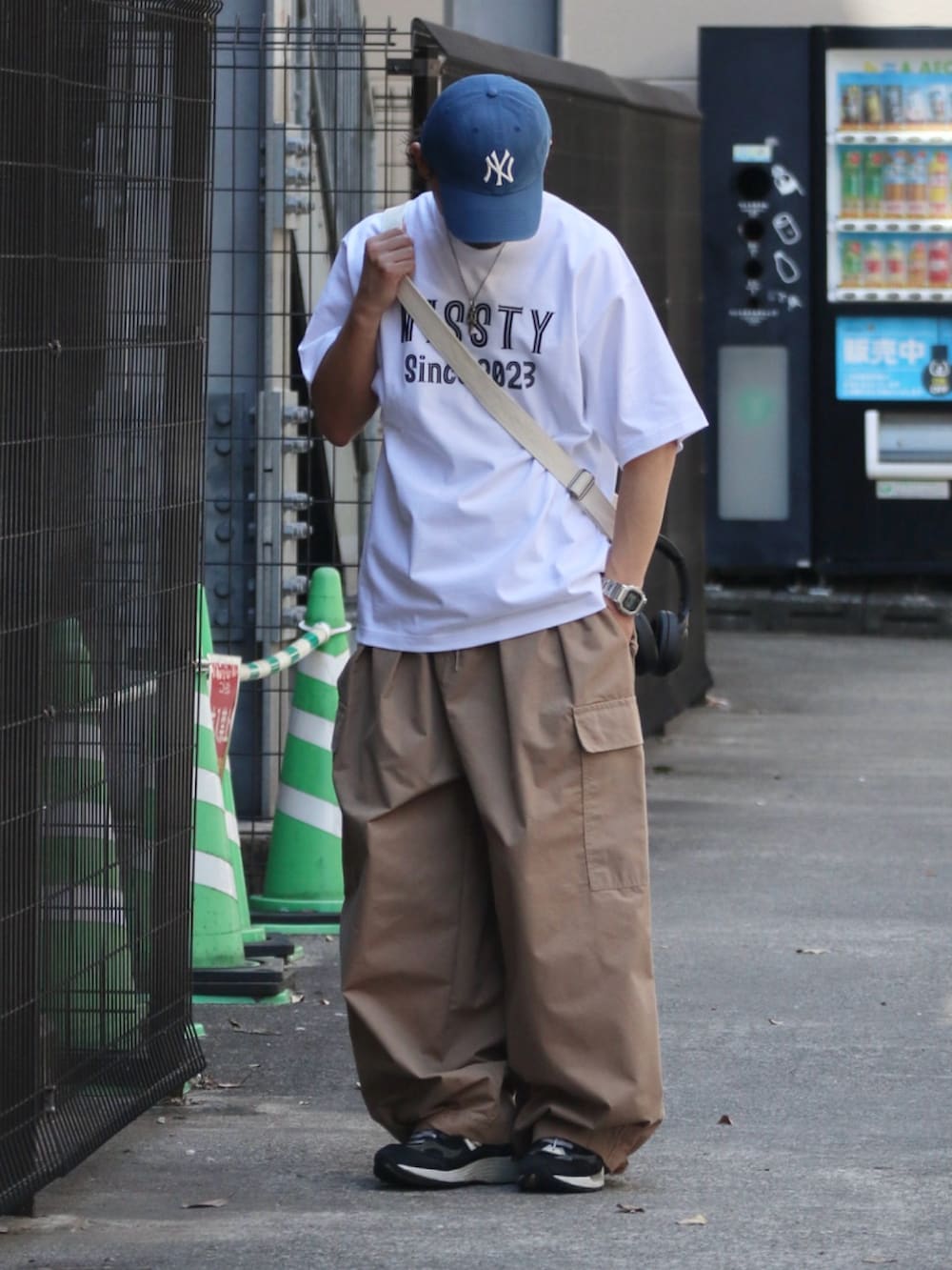 ホワイト系のTシャツ/カットソー、ホワイト系のトートバッグ、シルバー系のピアス（片耳用）を着用したメンズの夏コーディネートの3枚目の写真