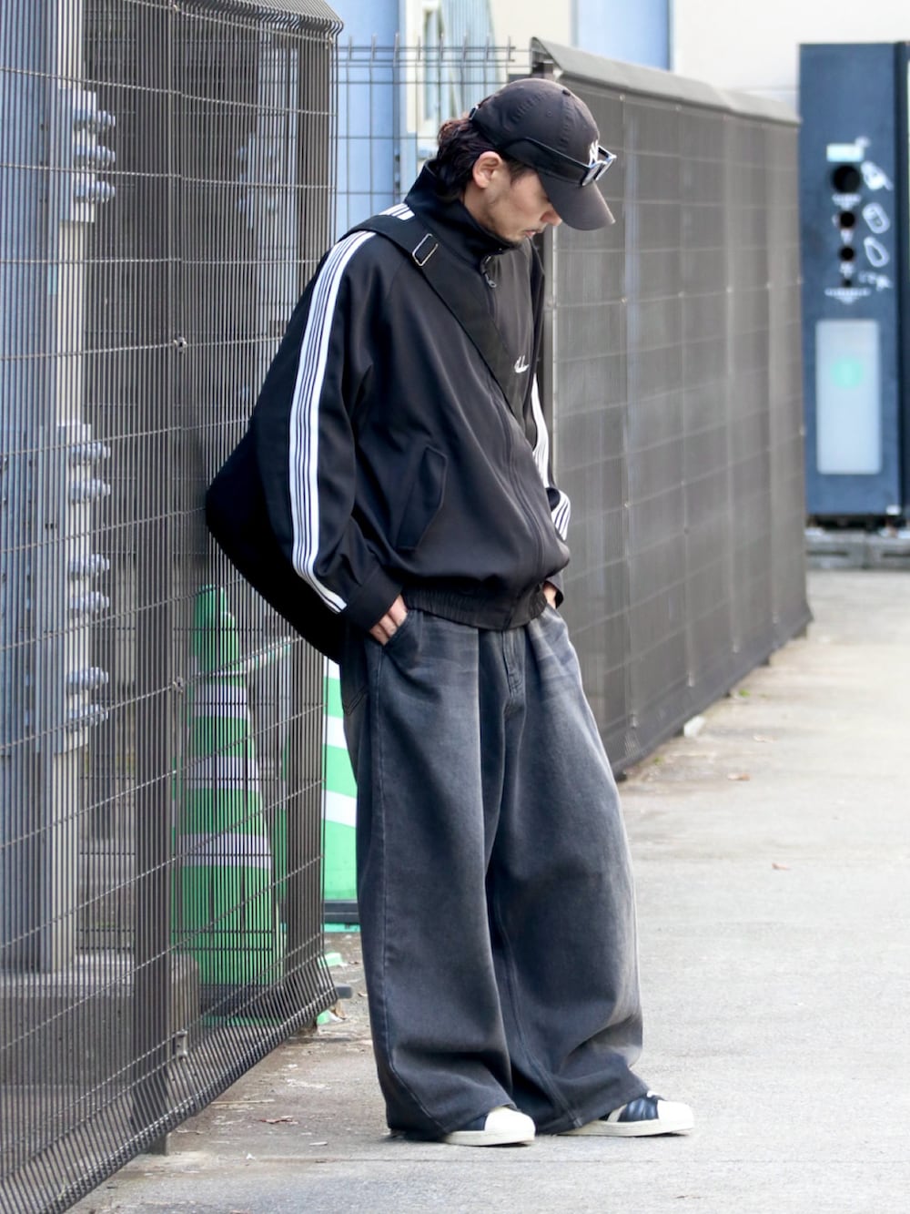 ブラック系のその他アウター、ブラック系のショルダーバッグを着用したメンズの冬コーディネートの2枚目の写真