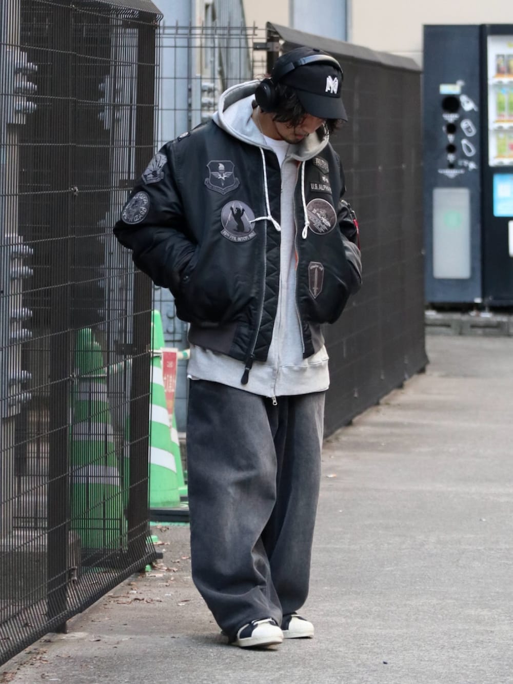 ブラック系のMA-1、グレー系のパーカー、ブラック系のデニムパンツを着用したメンズの冬コーディネートの3枚目の写真