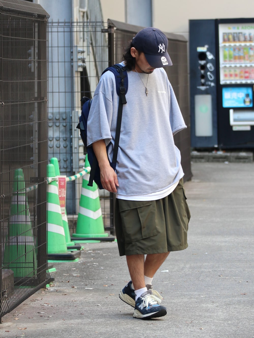 グレー系のTシャツ/カットソー、ブルー系のバックパック/リュック、グリーン系のカーゴパンツを着用したメンズの夏コーディネートの2枚目の写真