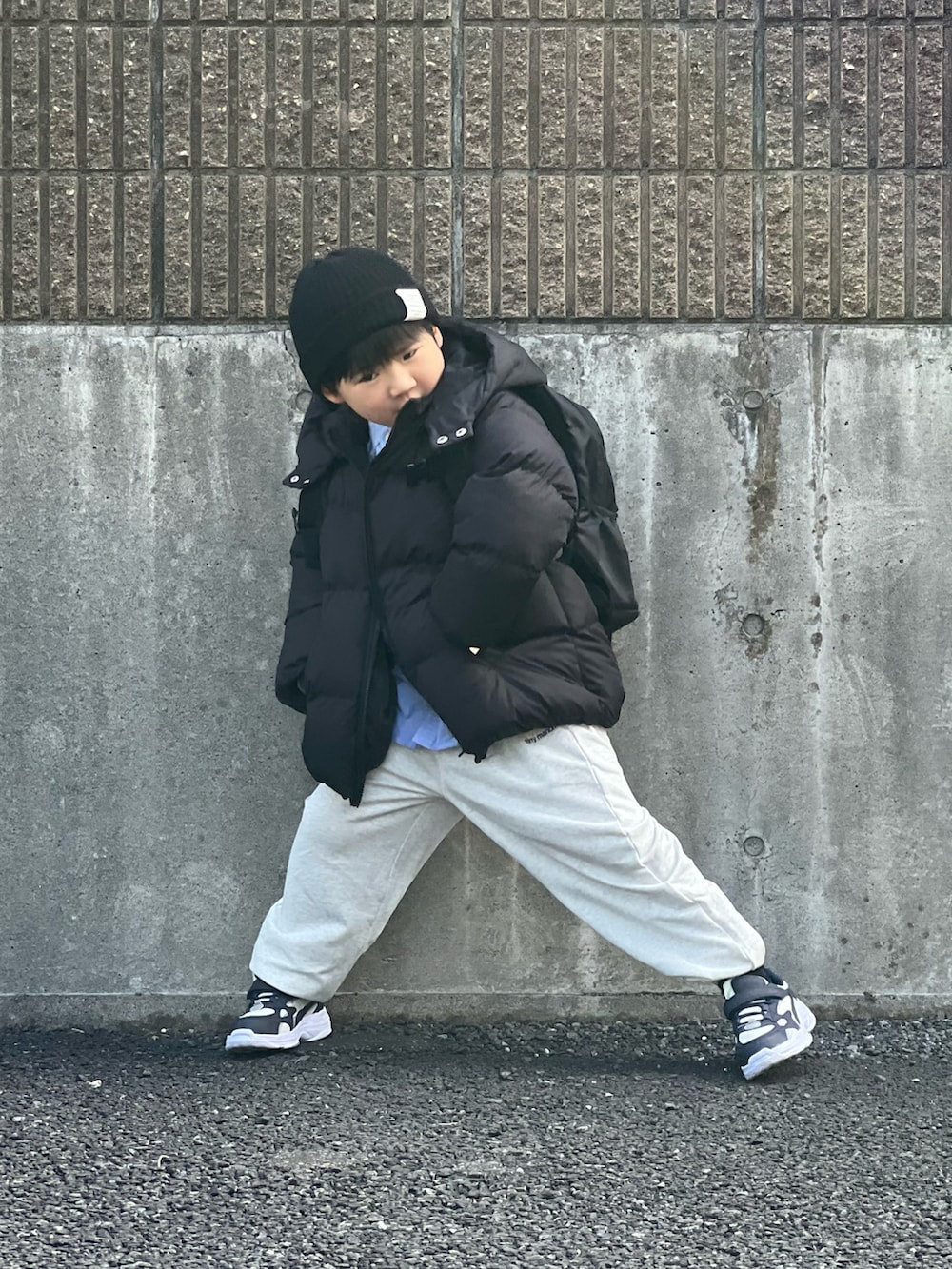 ブラック系のブルゾン、グレー系のスウェットパンツ、ホワイト系のスニーカーを着用したキッズの冬コーディネートの3枚目の写真