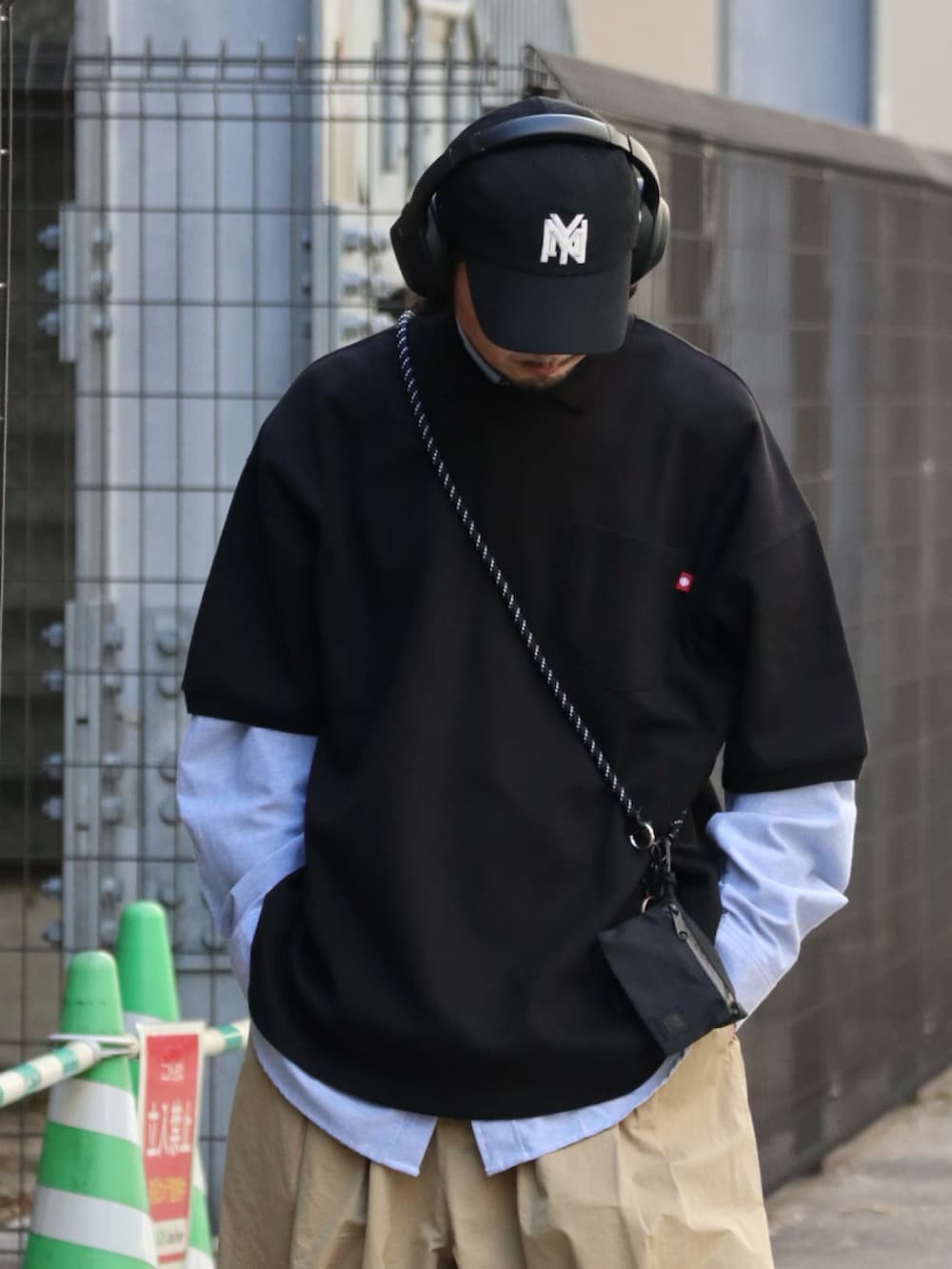 ブラック系のポロシャツ、ブラック系のスマホケース/カバーを着用したメンズの春コーディネートの3枚目の写真