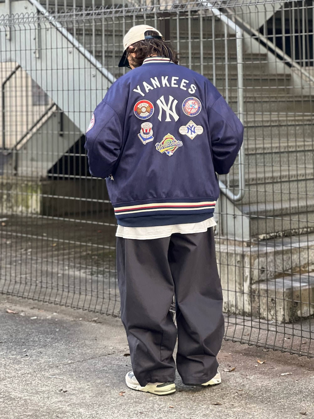 ブルー系のブルゾン、グレー系のその他パンツ、グレー系のスニーカーを着用したメンズの冬コーディネートの2枚目の写真