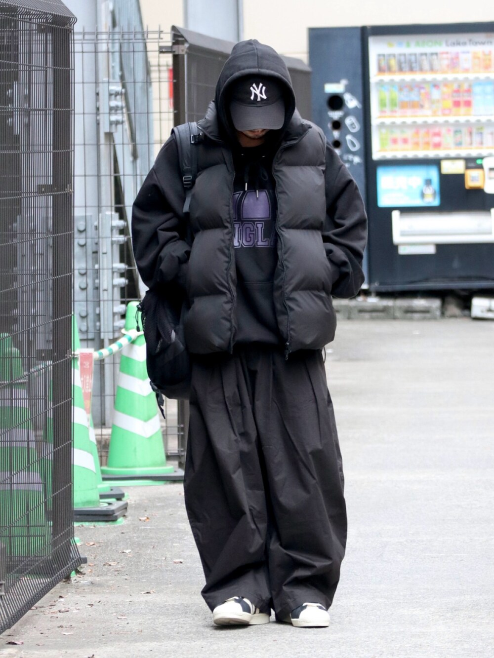 ブラック系のダウンベスト、ブラック系のパーカー、ブラック系のスニーカーを着用したメンズの秋コーディネートの2枚目の写真