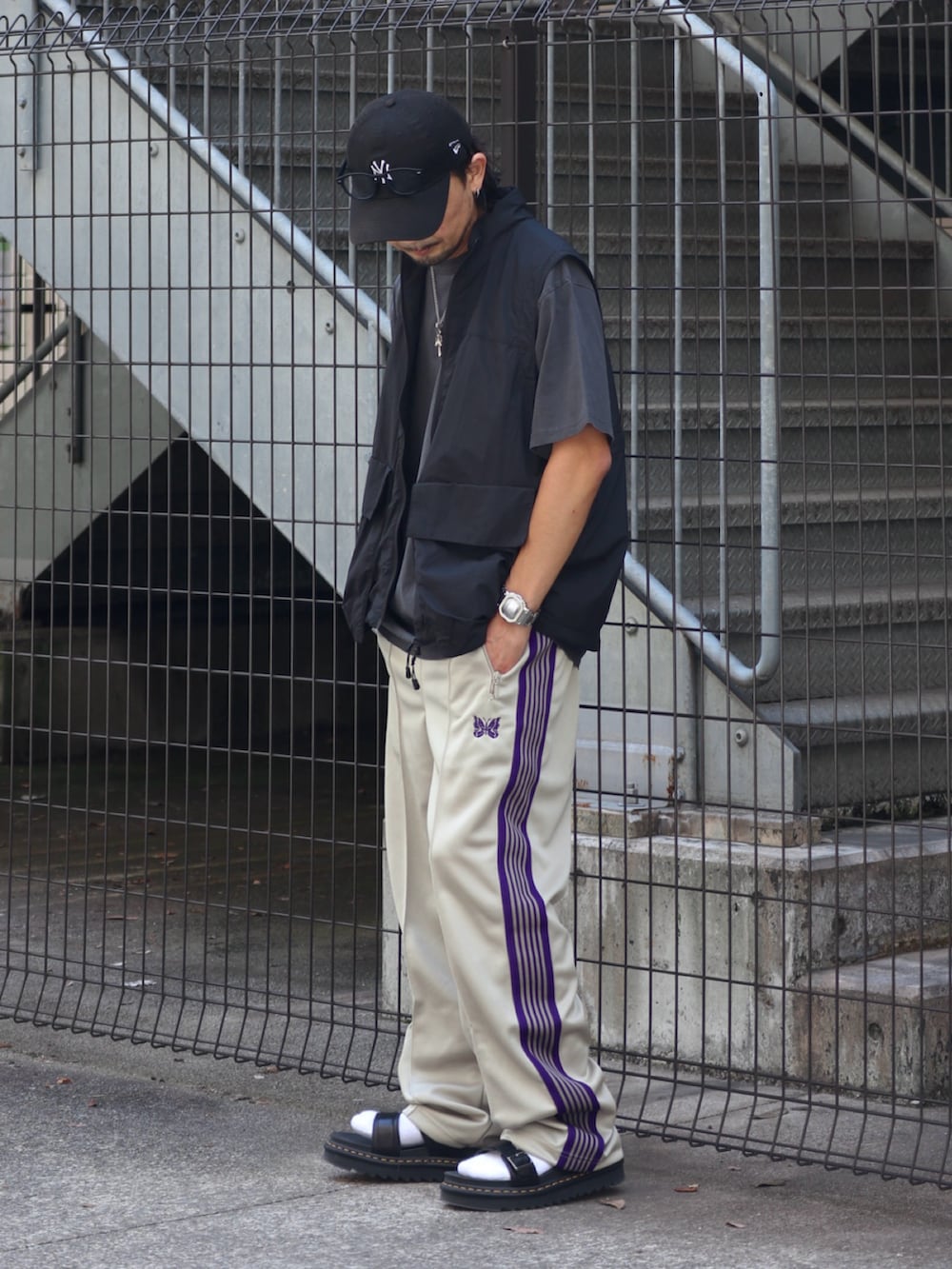 ベージュ系のその他パンツ、ブラック系のTシャツ/カットソー、ブラック系のサンダルを着用したメンズの夏コーディネートの2枚目の写真