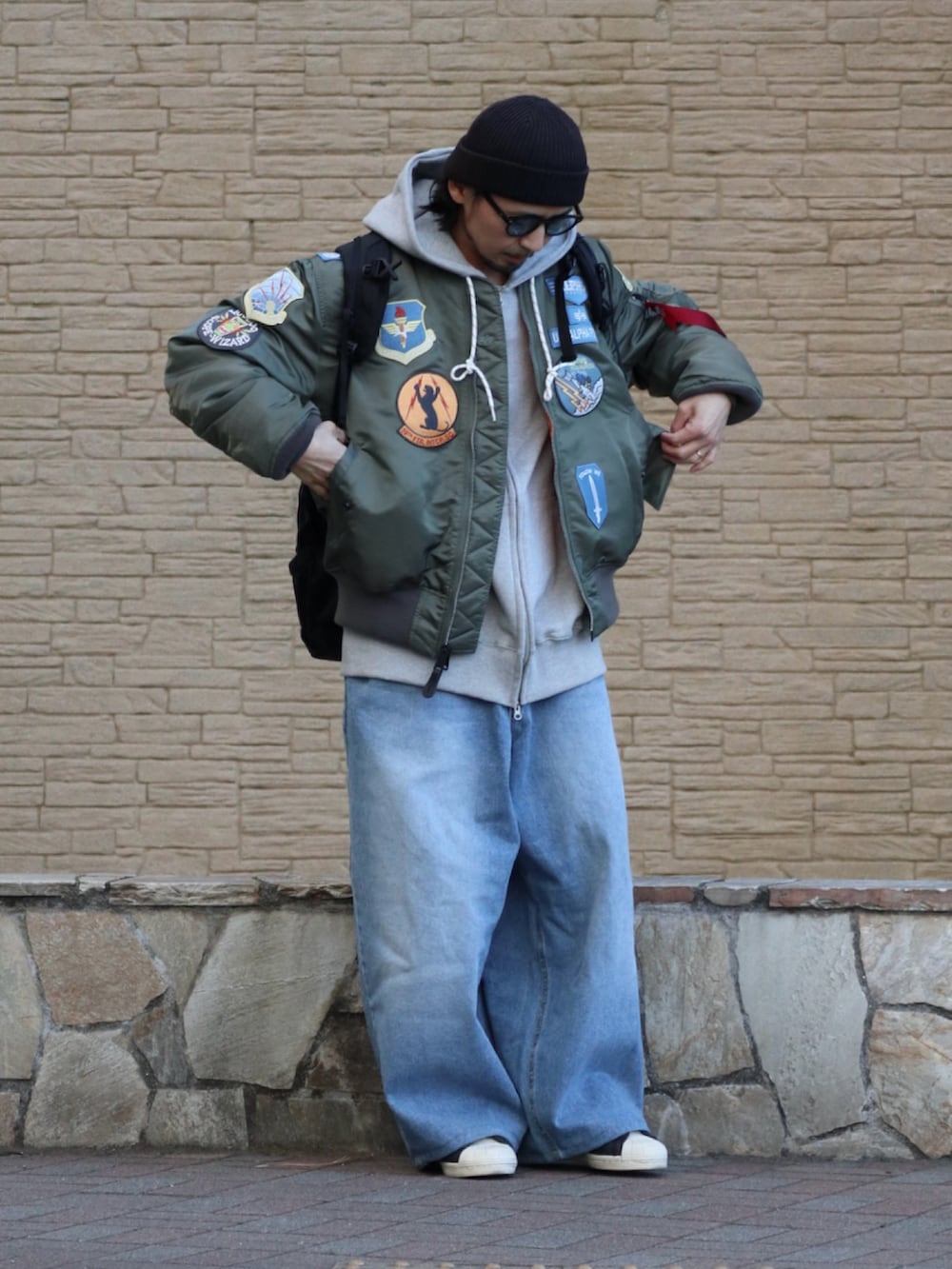 グレー系のパーカー、ブルー系のデニムパンツを着用したメンズの冬コーディネートの3枚目の写真