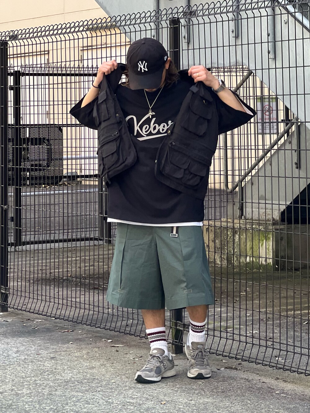 グリーン系のパンツ、ブラック系のTシャツ/カットソー、ブラック系のベストを着用したメンズの夏コーディネートの2枚目の写真