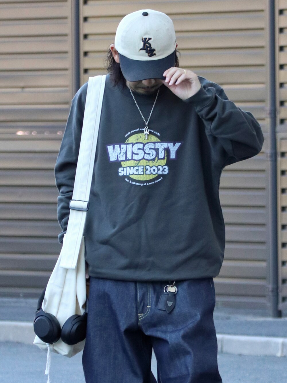 グレー系のスウェット、ホワイト系のスニーカーを着用したメンズの秋コーディネートの2枚目の写真