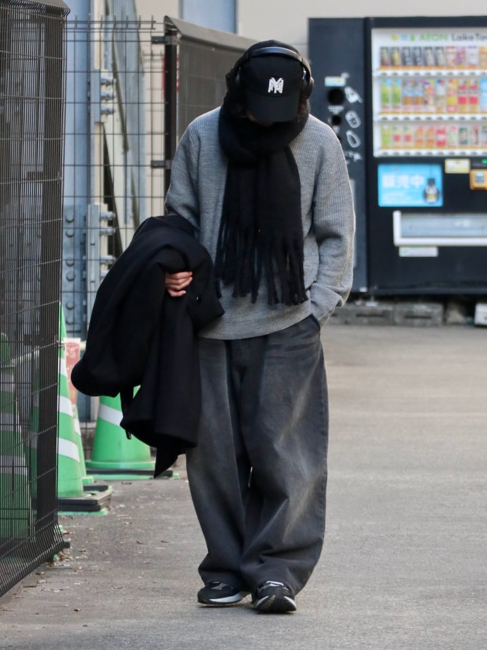 グレー系のニット/セーター、ブラック系のマフラーを着用したメンズの冬コーディネートの2枚目の写真