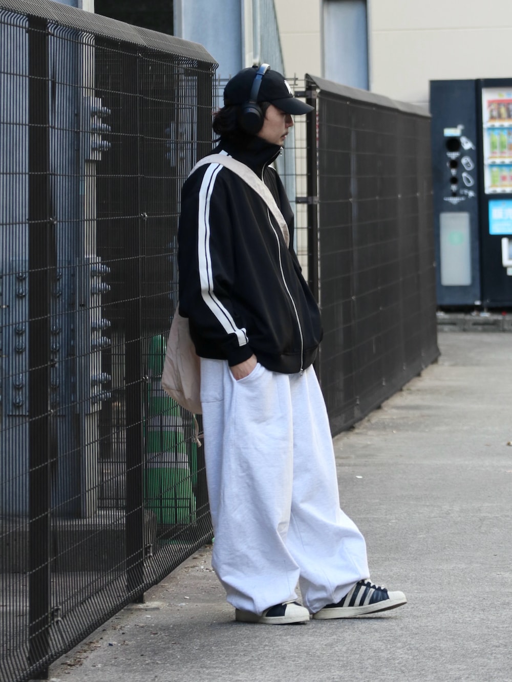 ブラック系のその他アウター、ホワイト系のスウェットパンツを着用したメンズの冬コーディネートの2枚目の写真