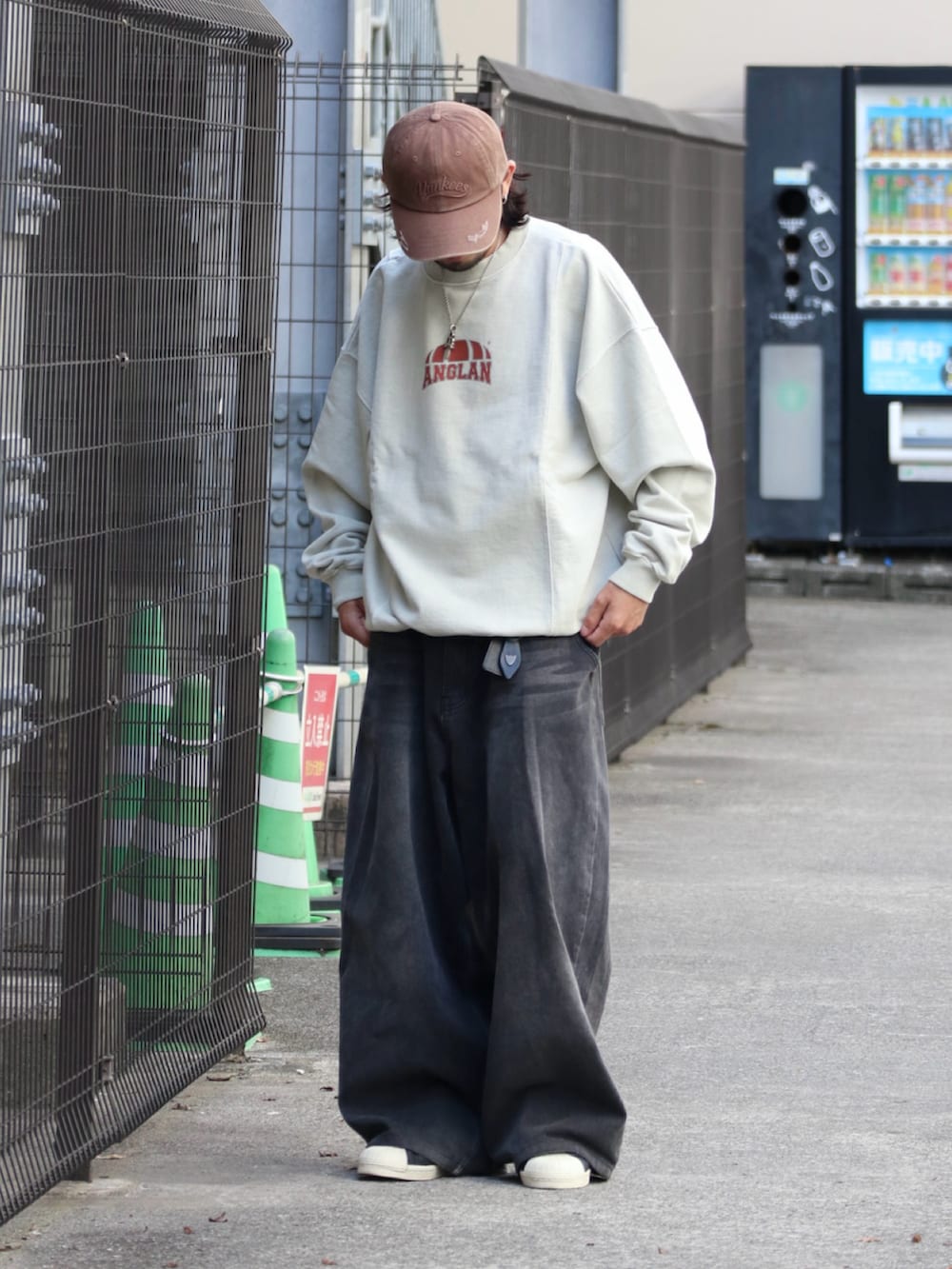 ホワイト系のスウェット、ブラウン系のキャップ、シルバー系のピアス（片耳用）を着用したメンズの夏コーディネートの3枚目の写真