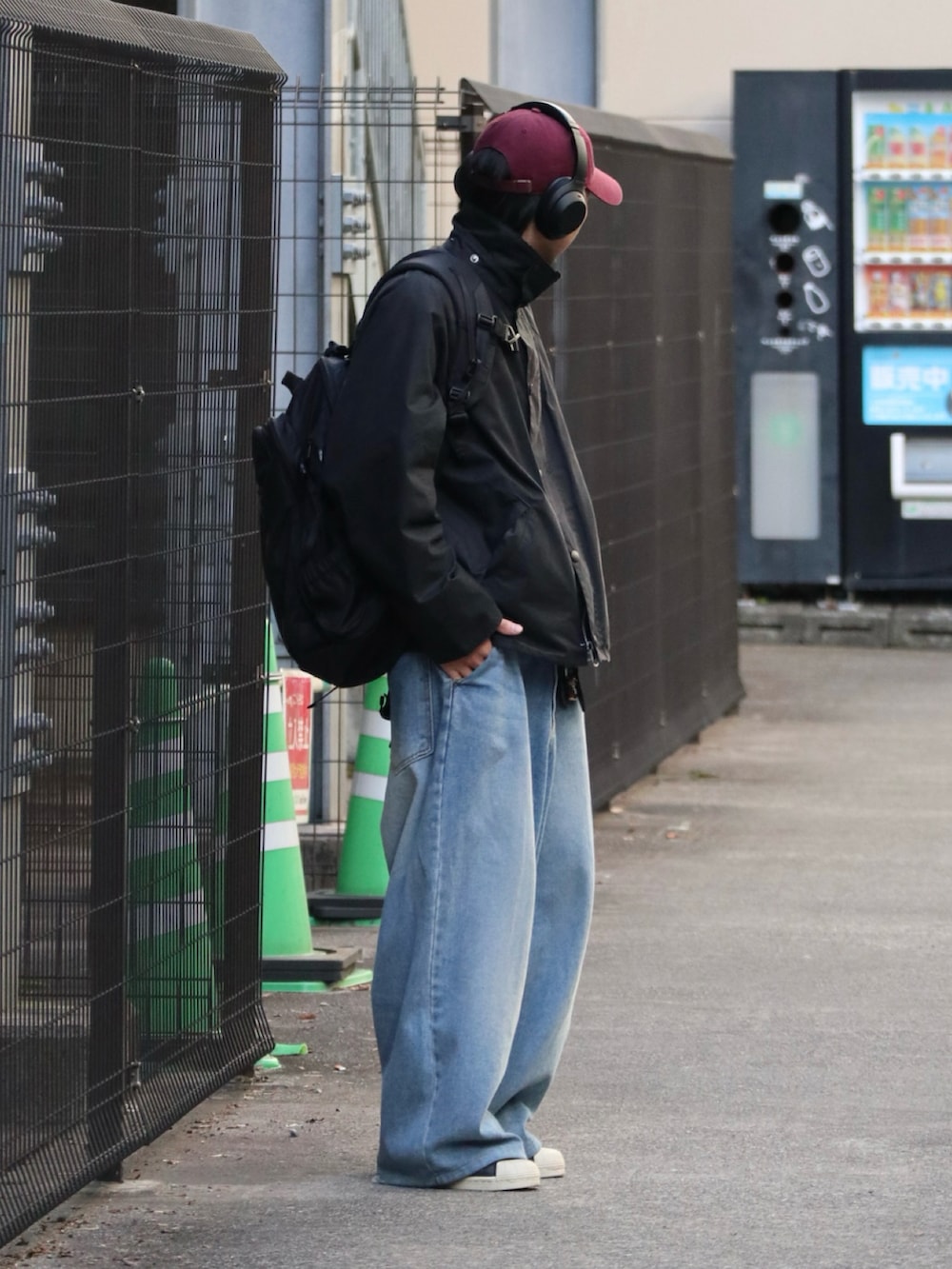 ブラック系のその他アウター、レッド系のキャップを着用したメンズの冬コーディネートの4枚目の写真