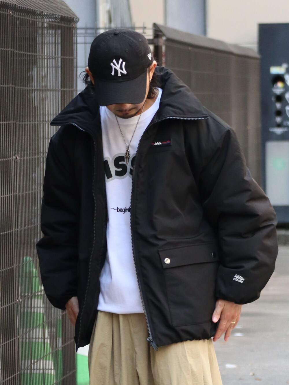 ブラック系のダウンジャケット/コート、ベージュ系のパンツを着用したメンズの冬コーディネートの2枚目の写真