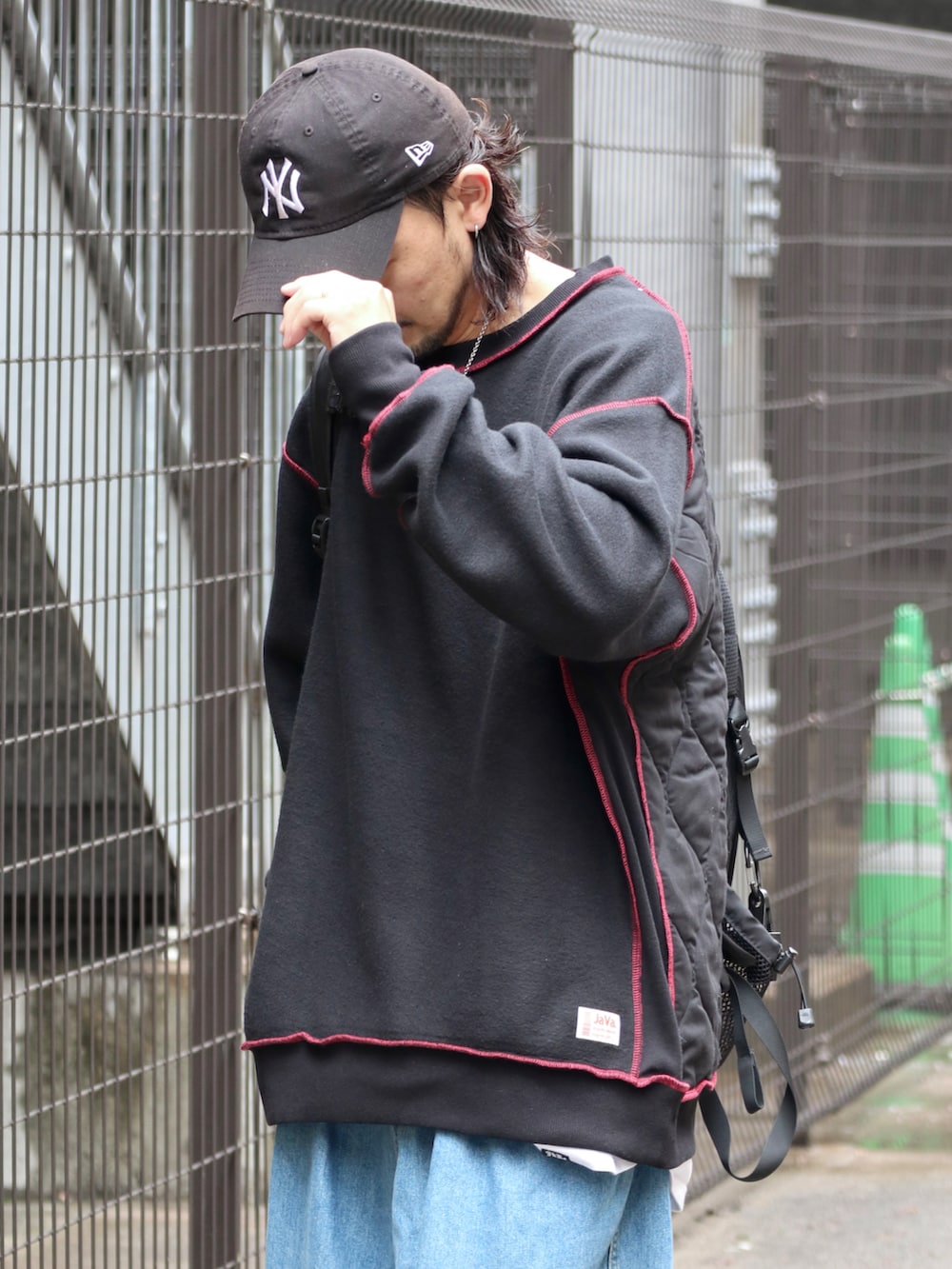 ブラック系のスウェット、ブルー系のデニムパンツを着用したメンズの秋コーディネートの3枚目の写真