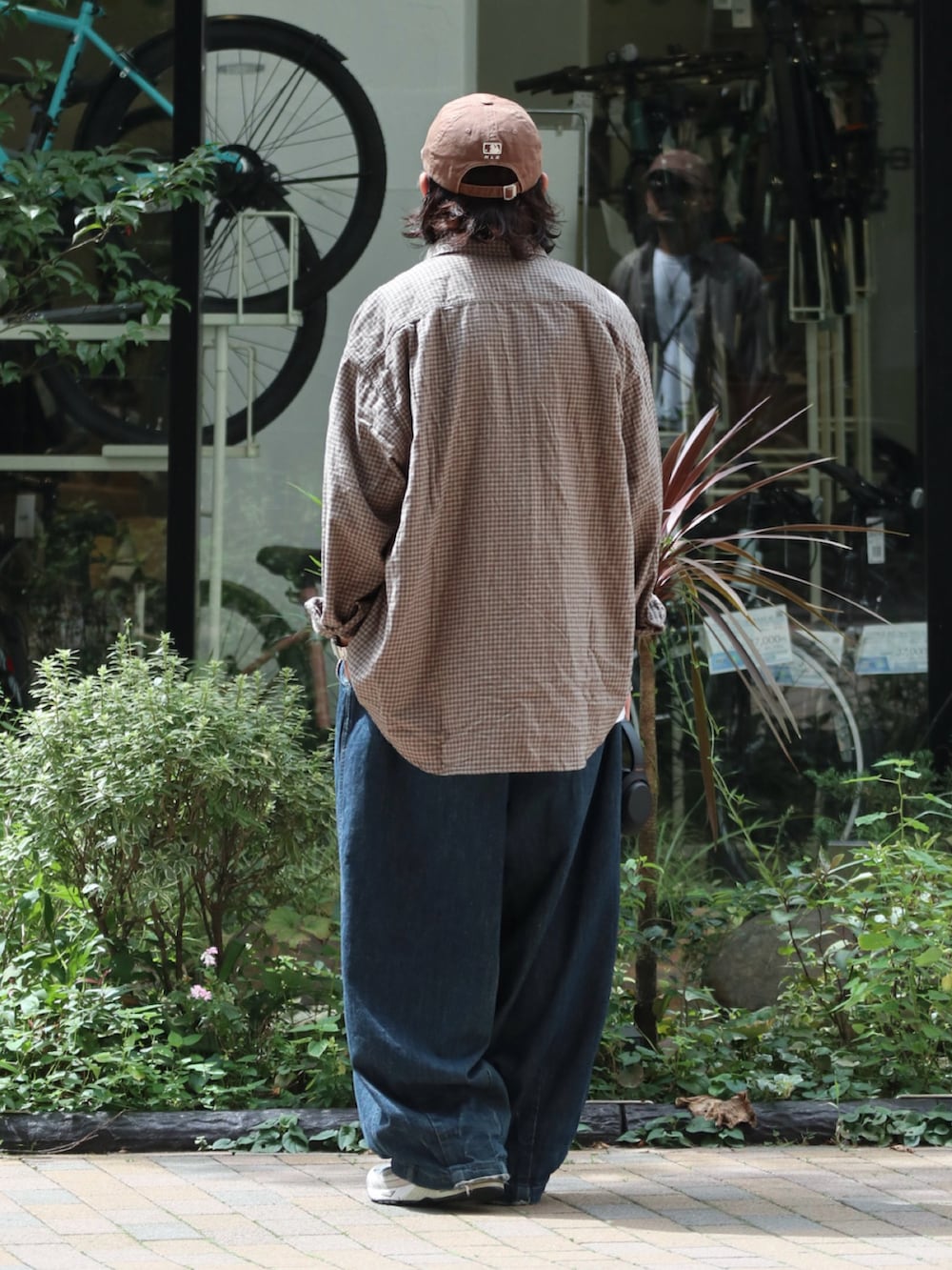 ブラウン系のシャツ/ブラウス、ブルー系のデニムパンツ、ブラウン系のキャップを着用したメンズの秋コーディネートの2枚目の写真