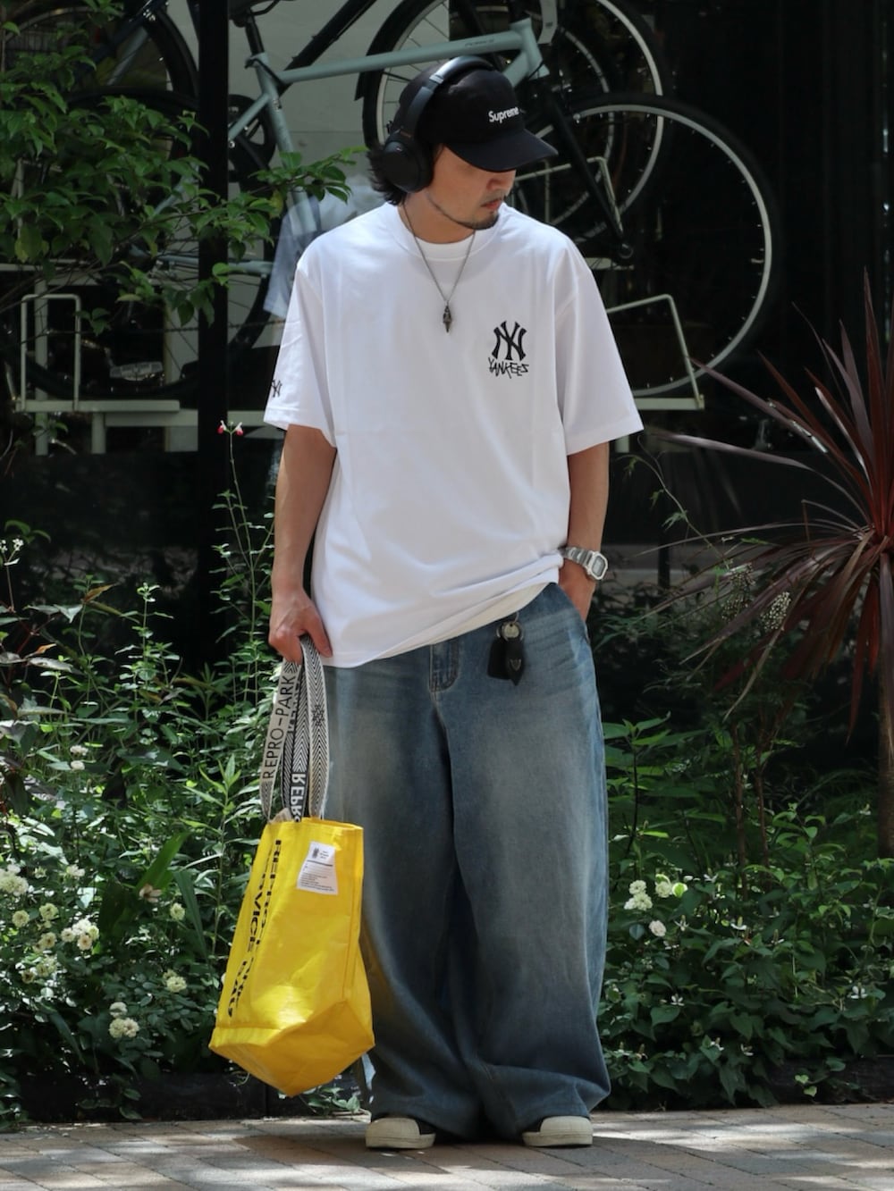 ホワイト系のTシャツ/カットソー、イエロー系のトートバッグを着用したメンズの夏コーディネートの3枚目の写真