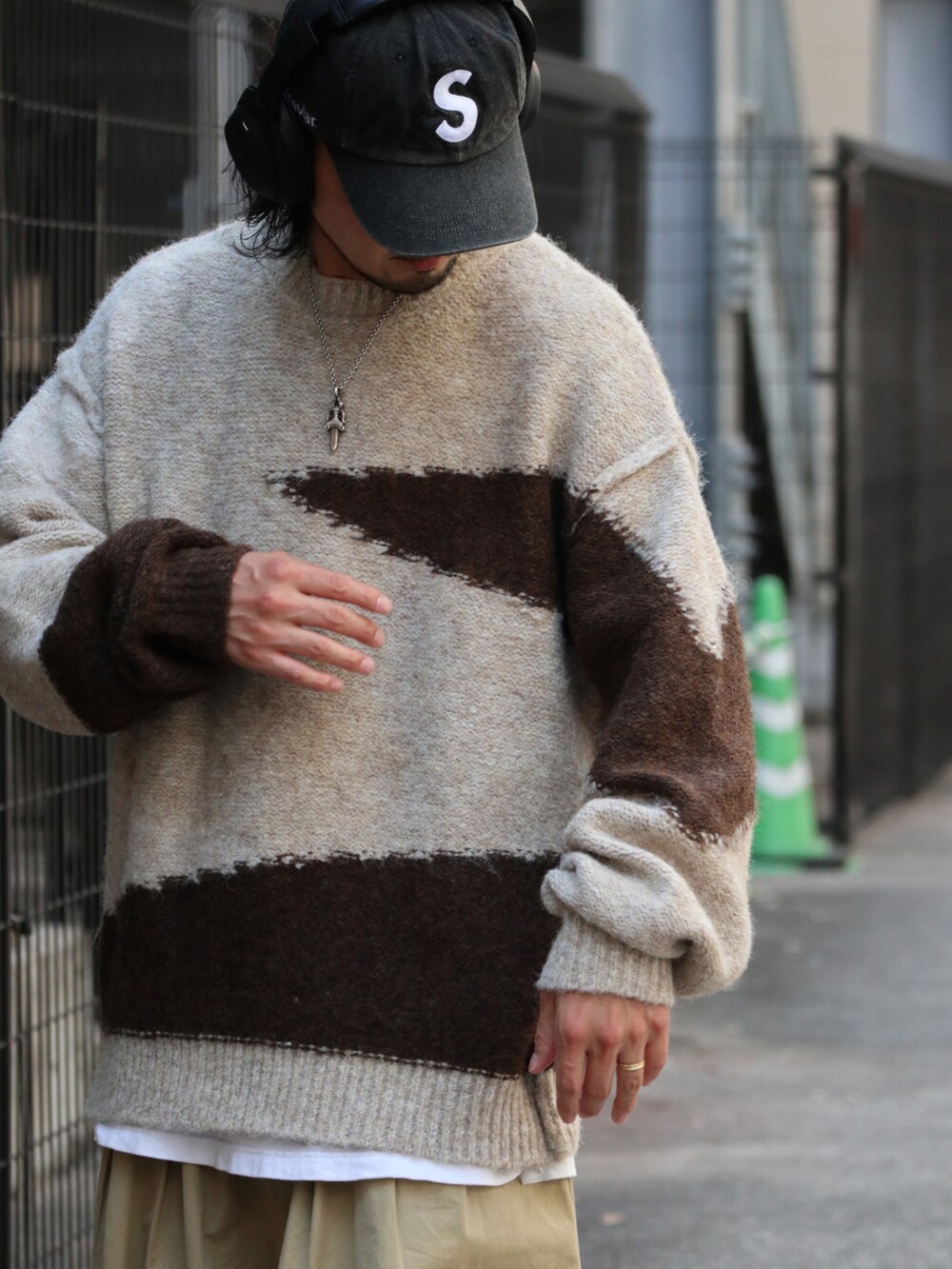 ブラウン系のニット/セーターを着用したメンズの秋コーディネートの2枚目の写真