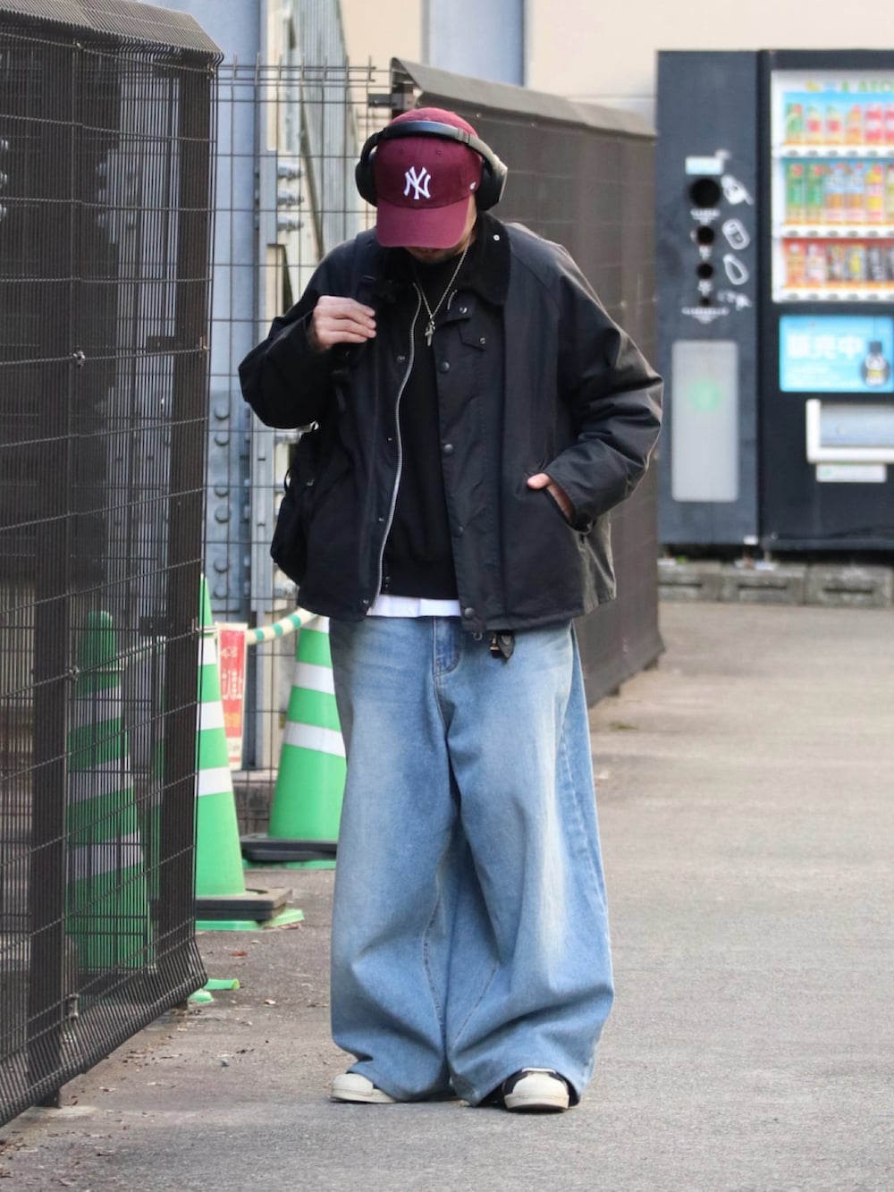 ブラック系のその他アウター、レッド系のキャップを着用したメンズの冬コーディネートの2枚目の写真