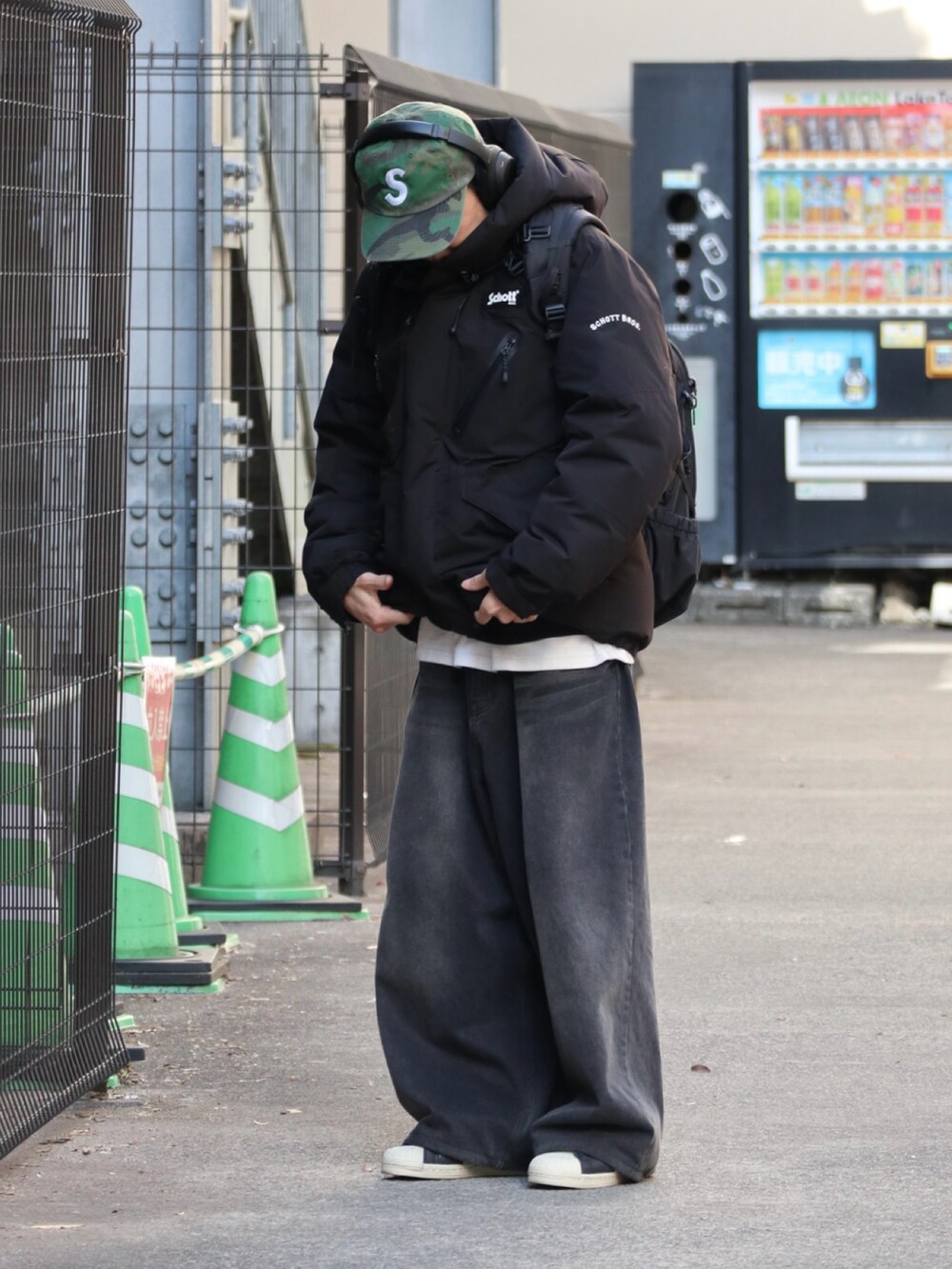 ブラック系のダウンジャケット/コート、ブラック系のデニムパンツ、ブラック系のスニーカーを着用したメンズの冬コーディネートの2枚目の写真