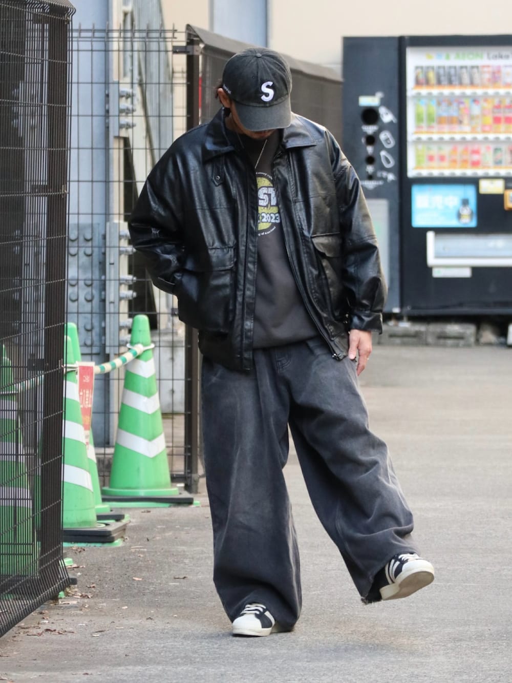 グレー系のスウェット、ブラック系のデニムパンツ、ブラック系のスニーカーを着用したメンズの冬コーディネートの2枚目の写真