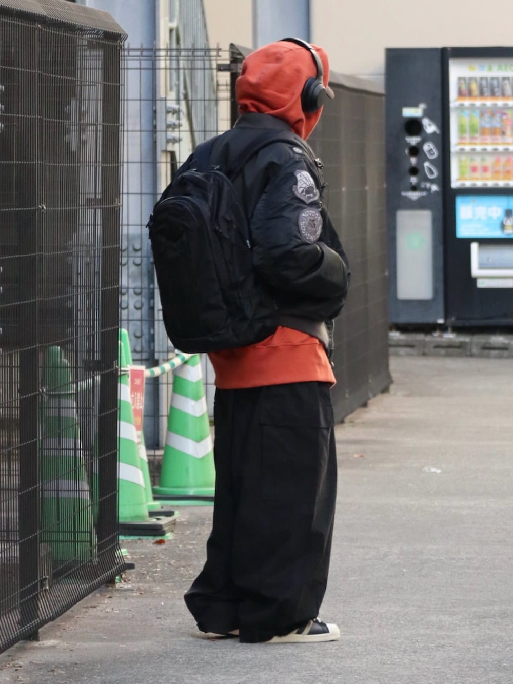 ブラック系のMA-1、オレンジ系のパーカー、ブラック系のその他パンツを着用したメンズの冬コーディネートの3枚目の写真