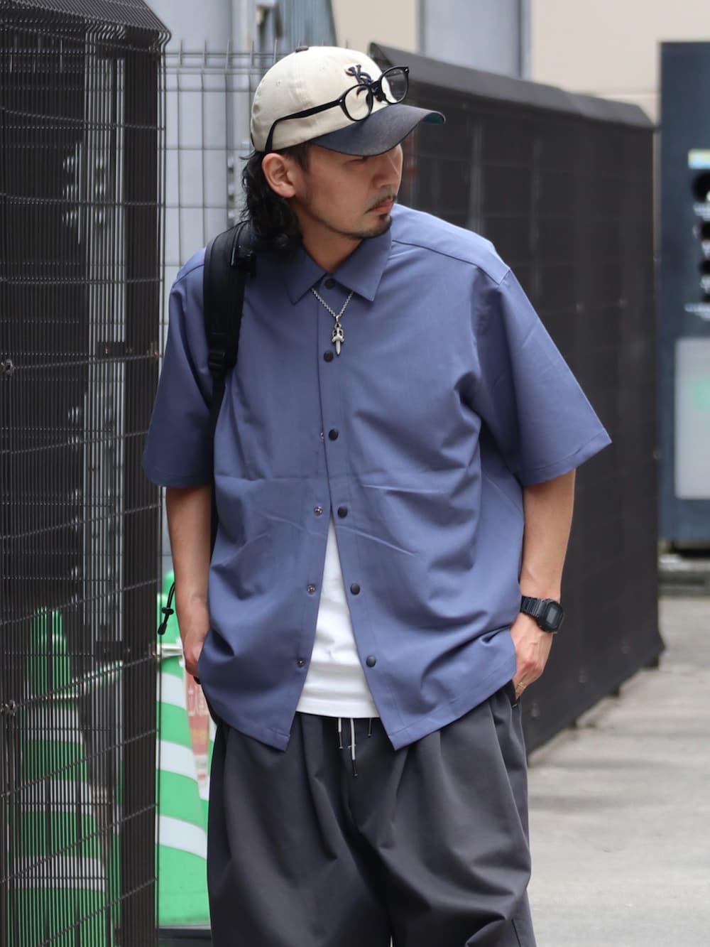 ブルー系のシャツ/ブラウス、グレー系のその他パンツ、ホワイト系のスニーカーを着用したメンズの夏コーディネートの2枚目の写真