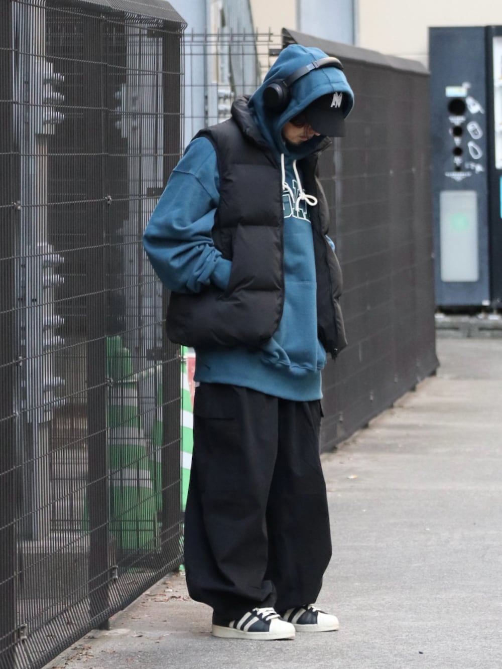 ブルー系のパーカー、ブラック系のダウンベスト、ブラック系のその他パンツを着用したメンズの冬コーディネートの3枚目の写真