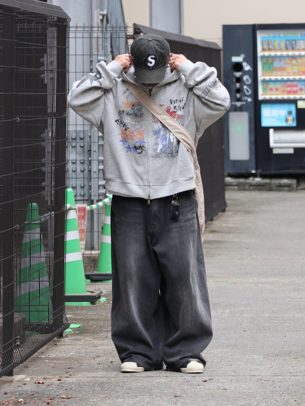 グレー系のパーカー、ブラック系のスニーカー、シルバー系のピアス（片耳用）を着用したメンズの秋コーディネートの2枚目の写真