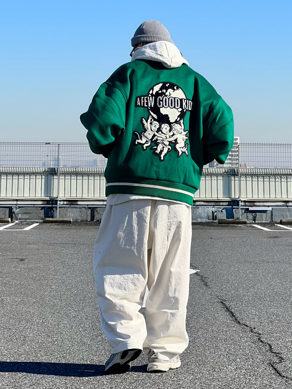 グリーン系のスタジャン、ホワイト系のその他パンツ、グレー系のスニーカーを着用したメンズの冬コーディネートの2枚目の写真