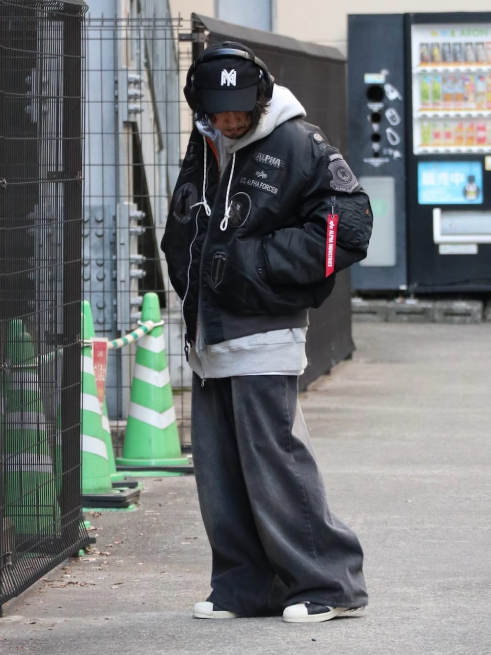 ブラック系のMA-1、グレー系のパーカー、ブラック系のデニムパンツを着用したメンズの冬コーディネートの2枚目の写真