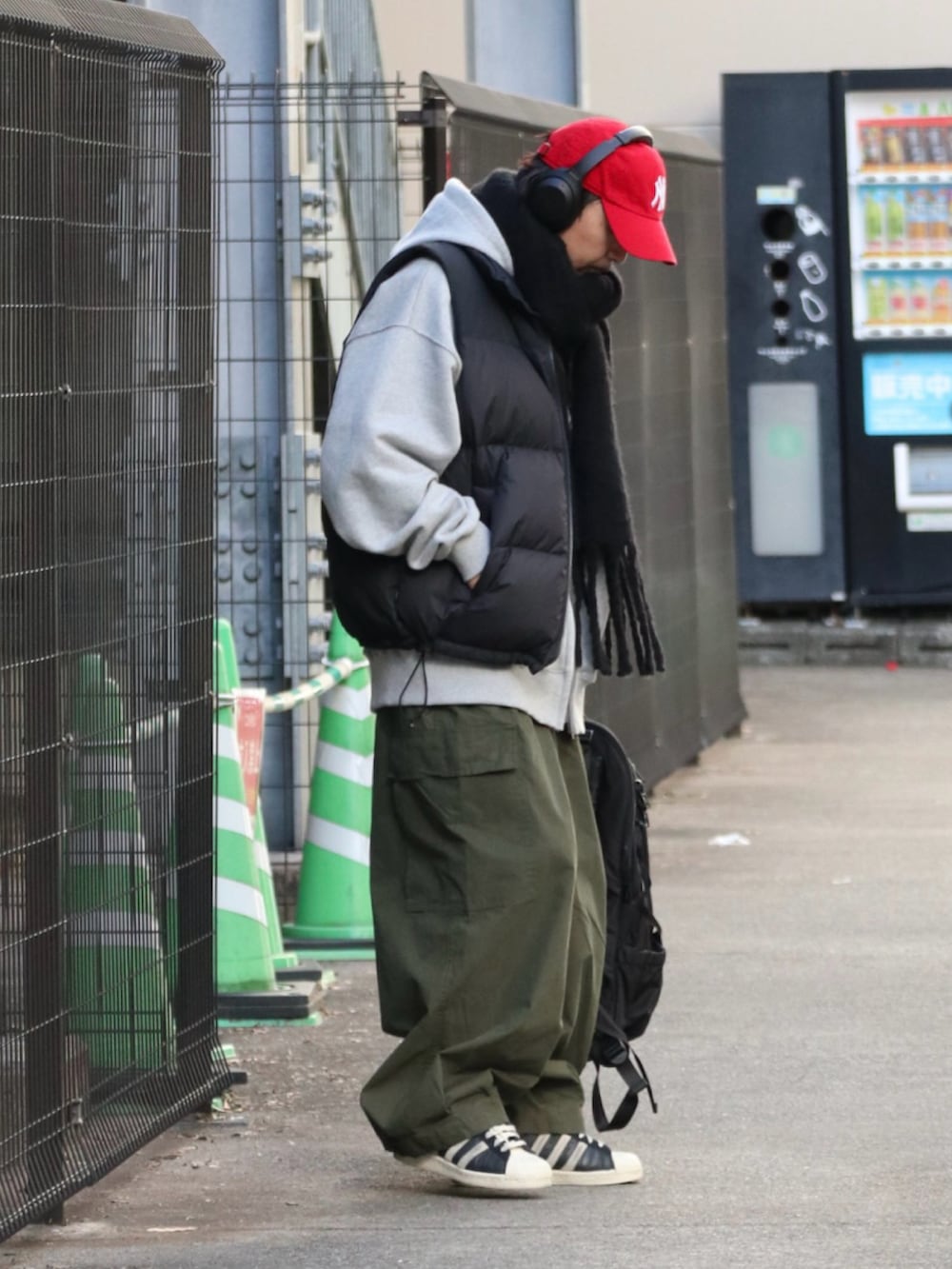 「ダウンベスト、冬コーデ、マフラー、カーゴパンツ、レイヤードスタイル、赤、キャップ、ストリート、スニーカー、お出かけコーデ」｜「FIRST DOWNのFDU-BUBBLE DOWN VEST MICROFT（ダウンベスト、ブラック系）」を使った、DAIGOさん（骨格ナチュラル・メンズ・166cm）の冬コーディネートの2枚目の写真