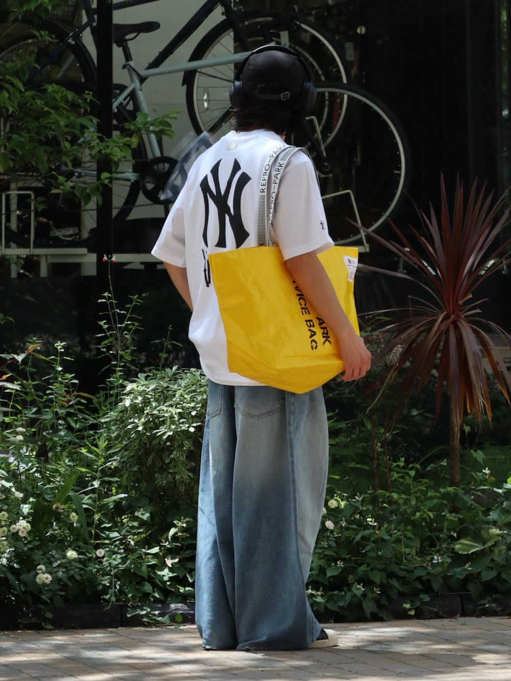 ホワイト系のTシャツ/カットソー、イエロー系のトートバッグを着用したメンズの夏コーディネートの2枚目の写真