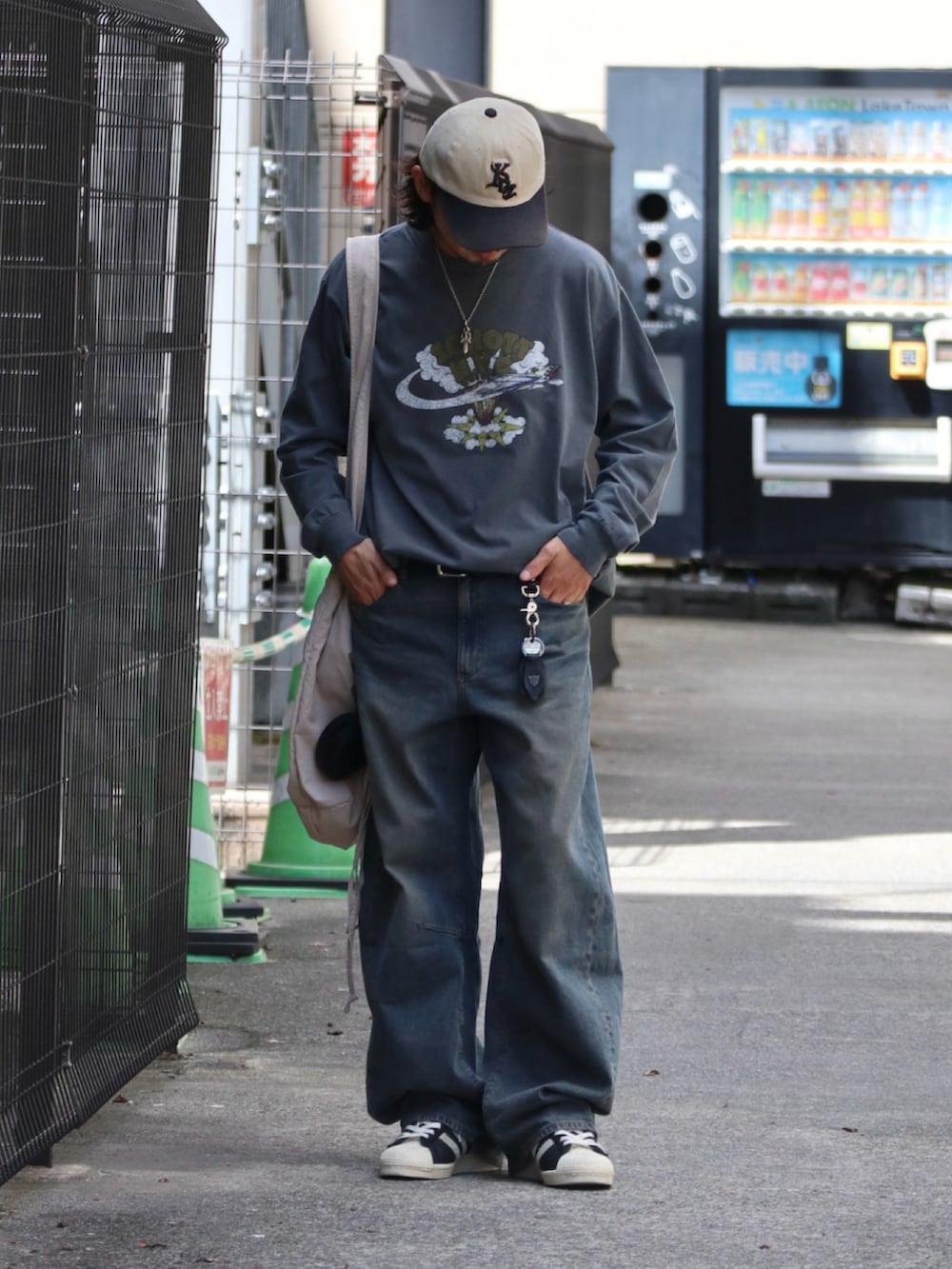 ブルー系のデニムパンツ、ブラック系のTシャツ/カットソー、ブラック系のスニーカーを着用したメンズの夏コーディネートの2枚目の写真